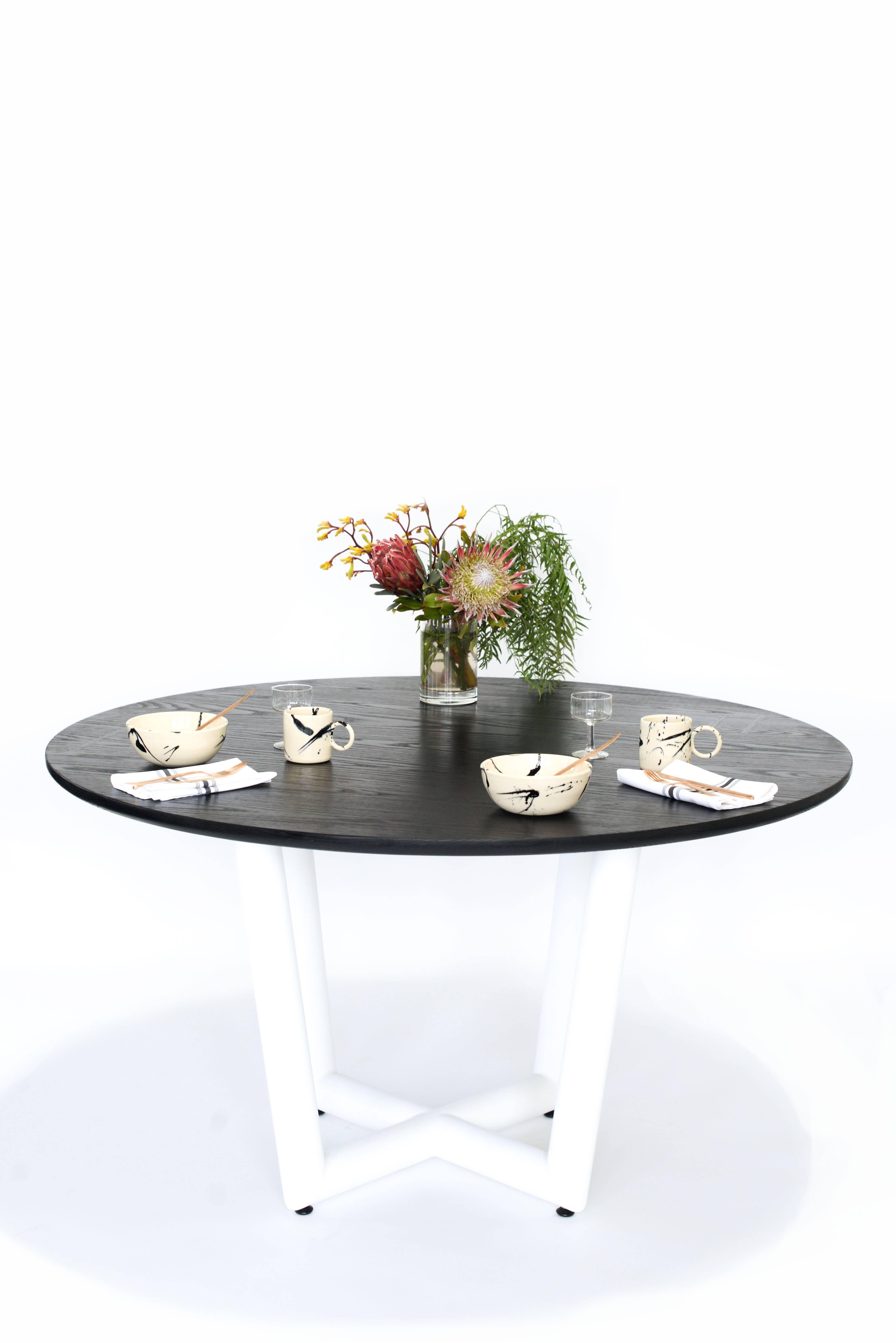 Metal Base, hand crafted solid wood constructed table top. Made in Los Angeles, California. 

Shown in ebonized oak round slab top, matte white powder coated base.  

Table top is available in ebonized oak, white oak, solid walnut, maple, ash, and