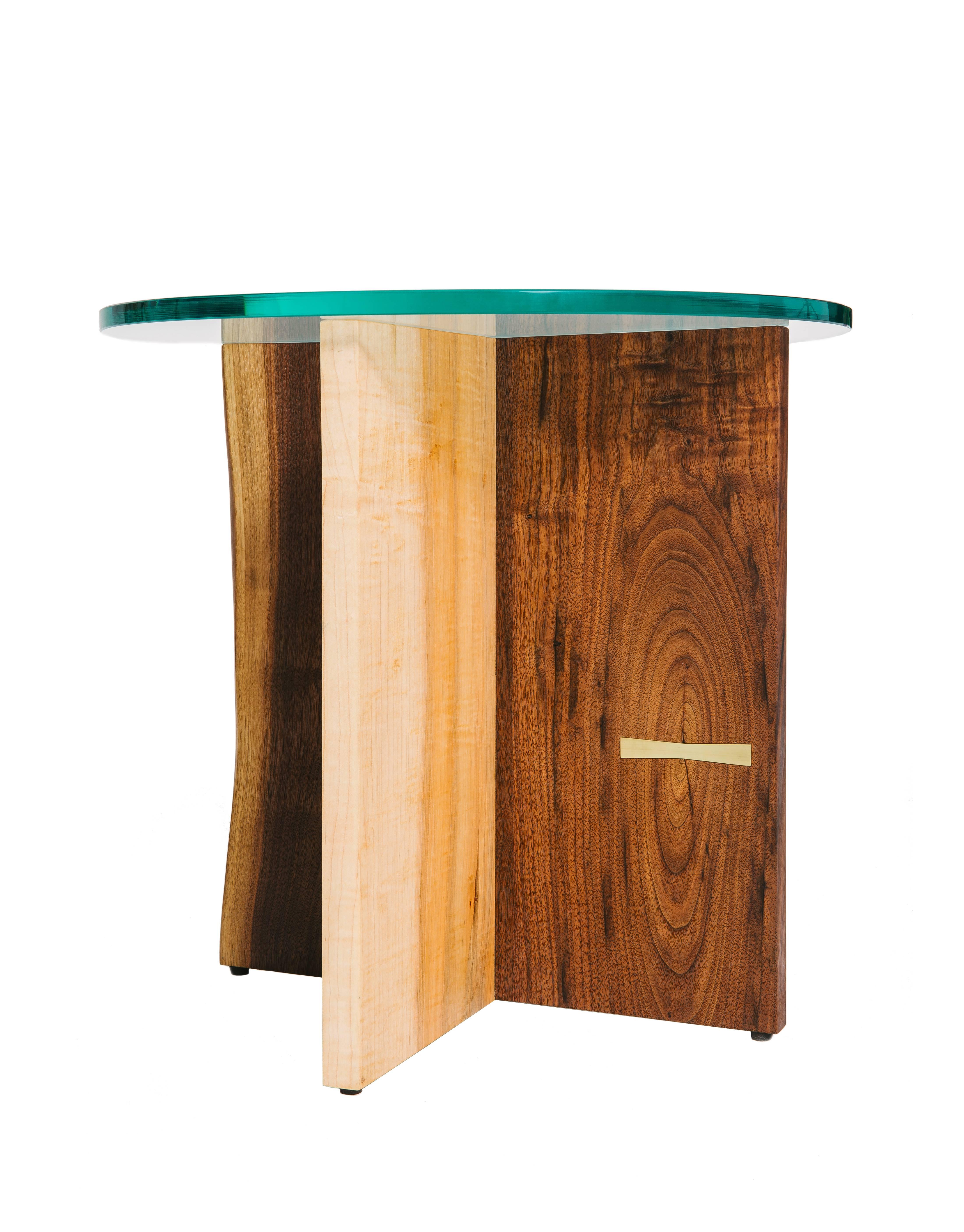Handcrafted natural edge intersected wood slab side table base. Fine metal Dutchman joint. Polished glass top. Handmade in Los Angeles, California.

Here shown in walnut and maple with a brass Dutchman Joint, and a clear tempered glass