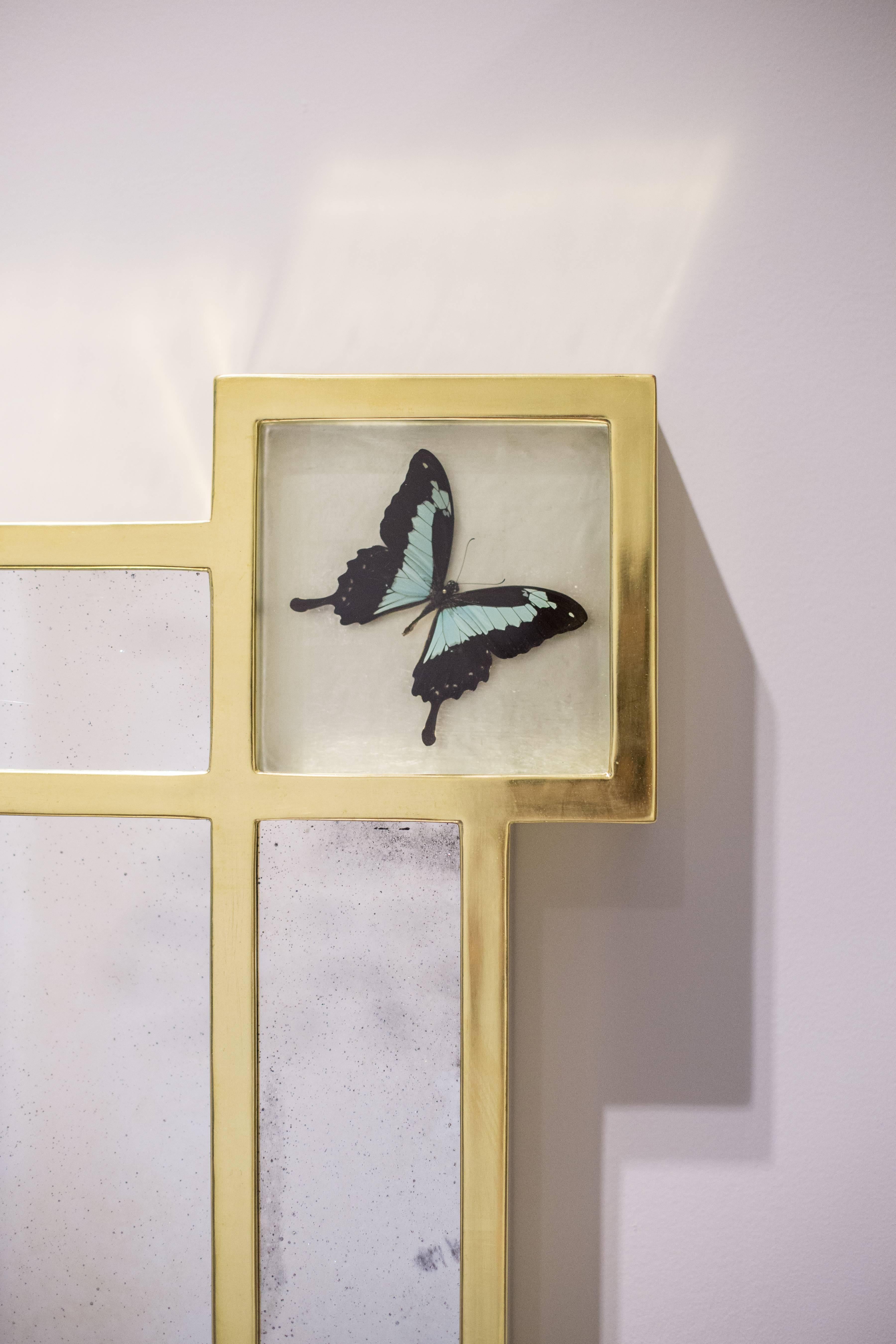 The frame is water gilded with 22 carat gold leaf and has a box in each corner containing a turquoise and black swallow butterfly. The interiors of the boxes are oil gilded with pale lemon 16.9 carat gold leaf. The mirror glass is hand drawn and