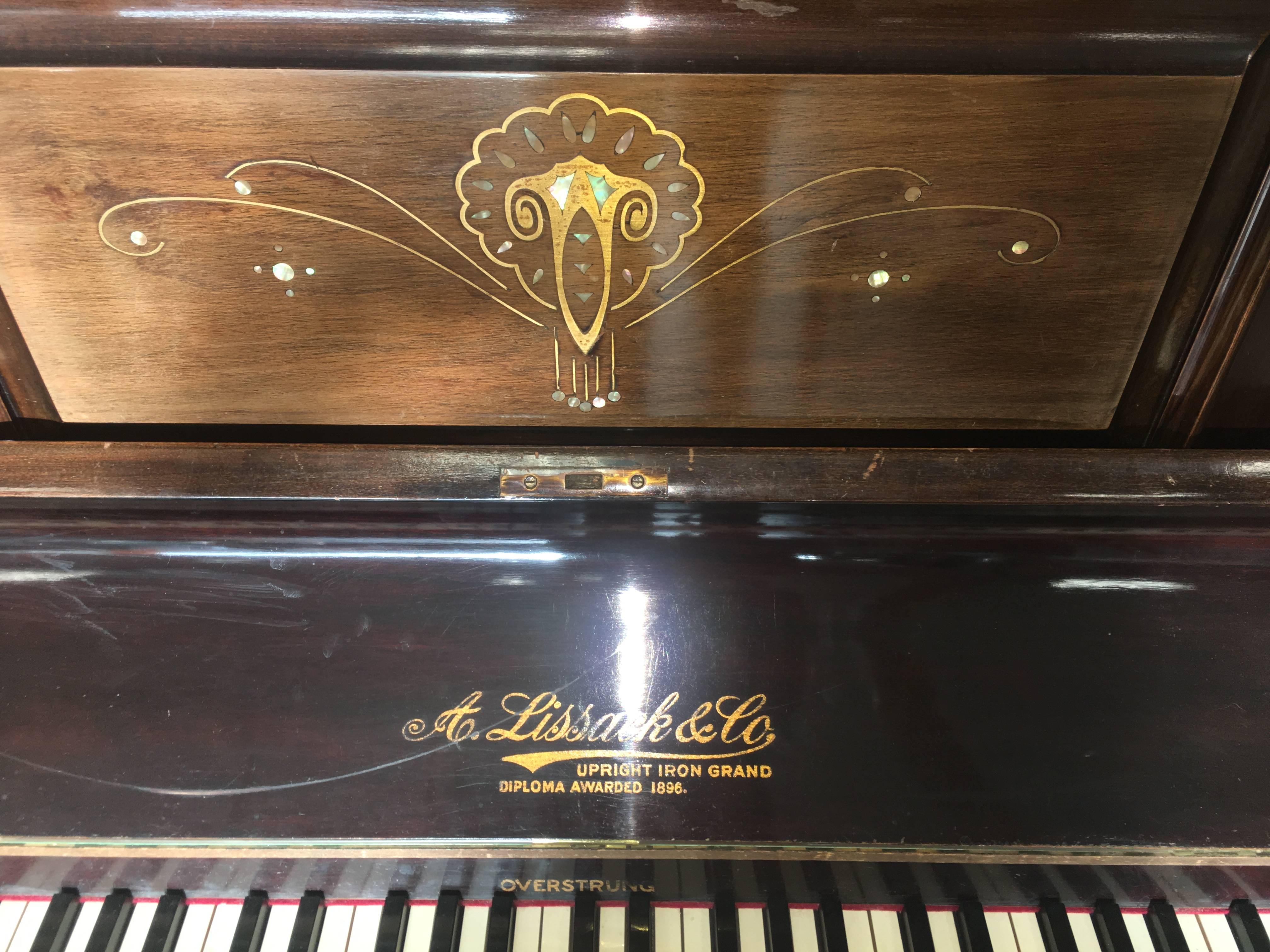 Magnifique piano Lissack & Co
Début des années '900:: palissandre:: châssis métallique:: décorations en nacre
1896 Lissack & Co piano droit en fer avec diplôme. 

Chaise 
50 / 36 diam 
            