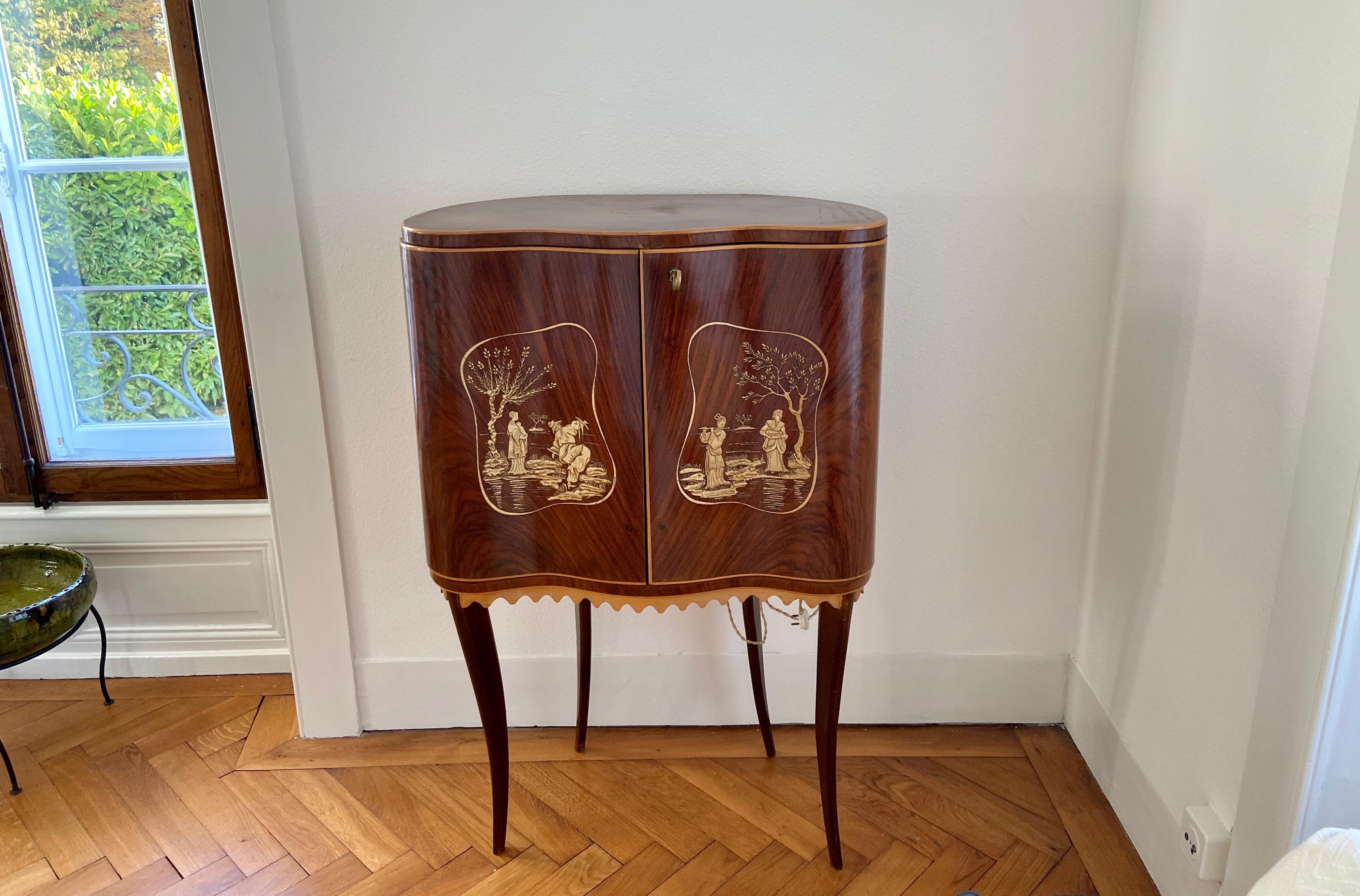 Attributed to Paolo Buffa, circa 1946. An elegant standing dry bar in walnut and birch wood with beautiful Asian decorations on both front doors. The inside of this beautiful cabinet is full of glass mirror parts which is very particular for the