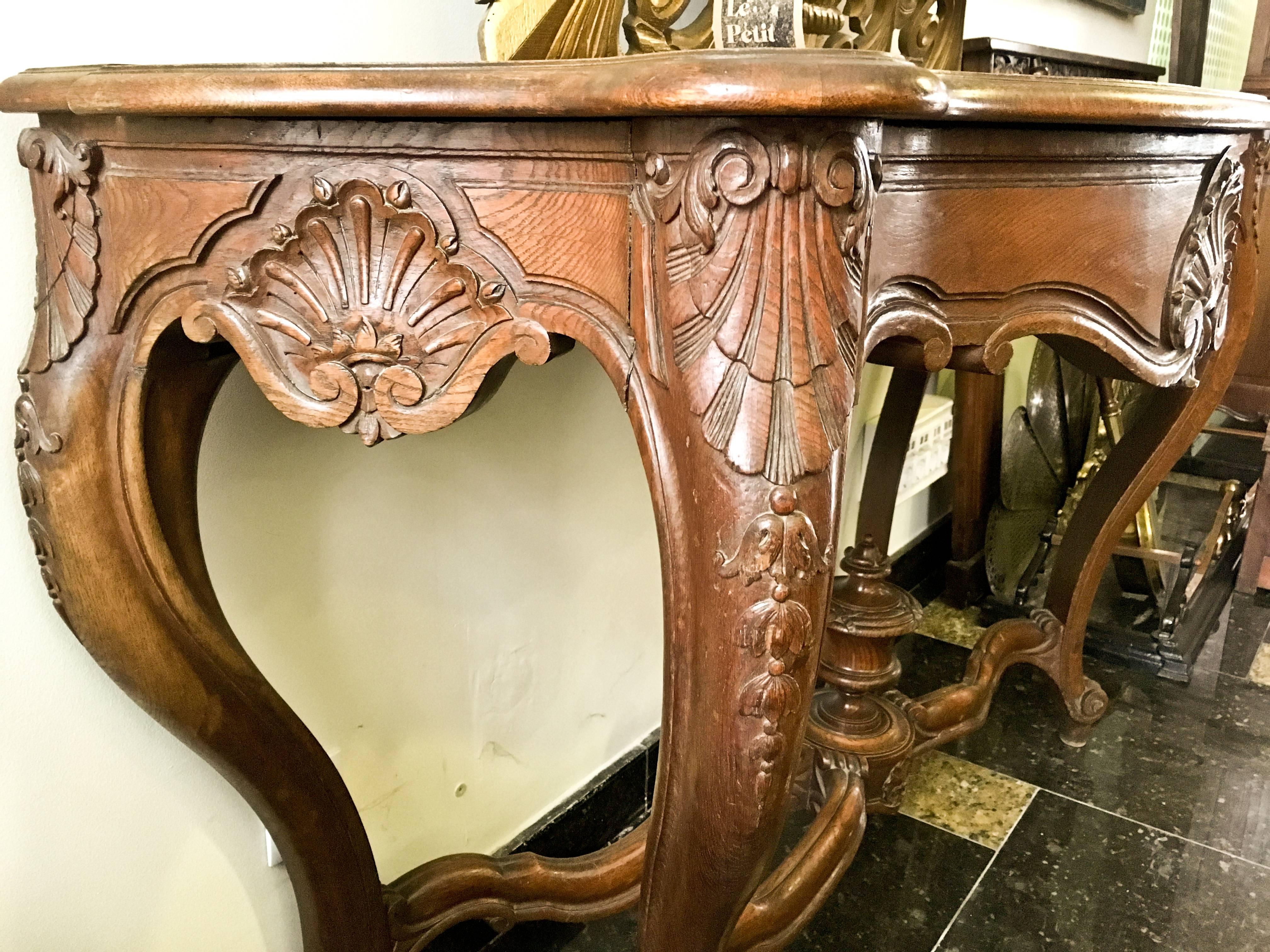 19th century French Regence style beautifully carved with leaves walnut console. Red marble top with hidden drawer underneath, over hand-carved frieze supported by four cabriole legs connected by X-form stretchers centered by large urn. Very massive