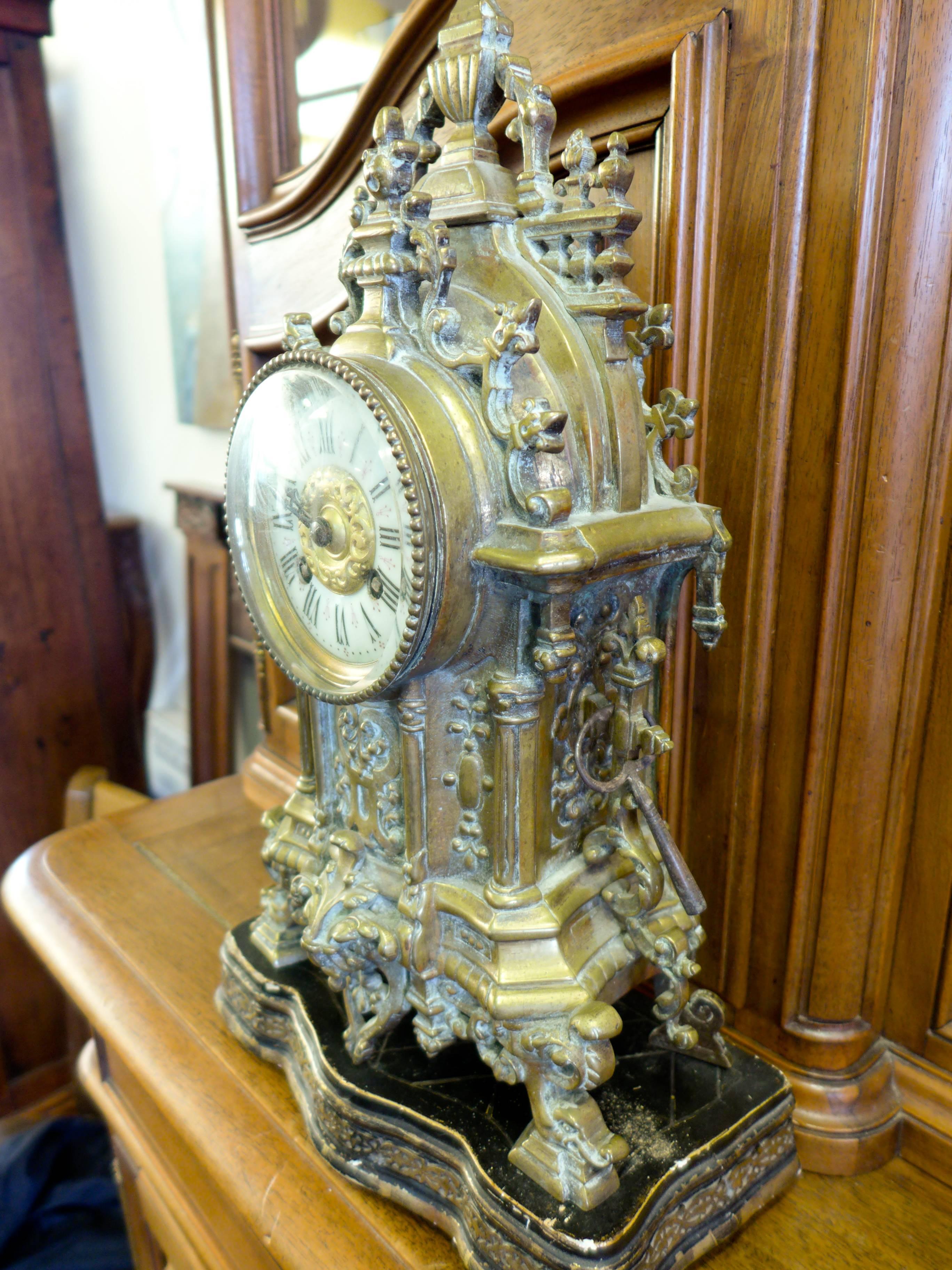 Great 19th century, impressive French, bronze mantel clock in Gothic style. Beautifully ornated It rests on its four feet over a nice wood stand.
The white enamelled dial has Roman numerals.
This clock will make a statement wherever it is