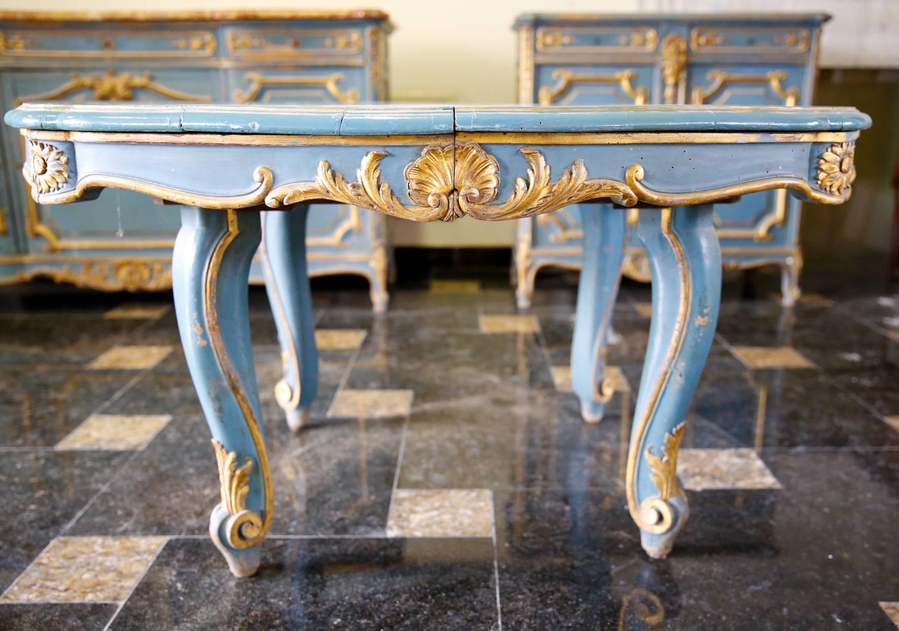 Antique French 19th century oval extending table with two separate extension leaves. The table is done by solid wood painted in light blue with shine gold accents, it has four beautifully carved legs and additional four hidden legs to support the