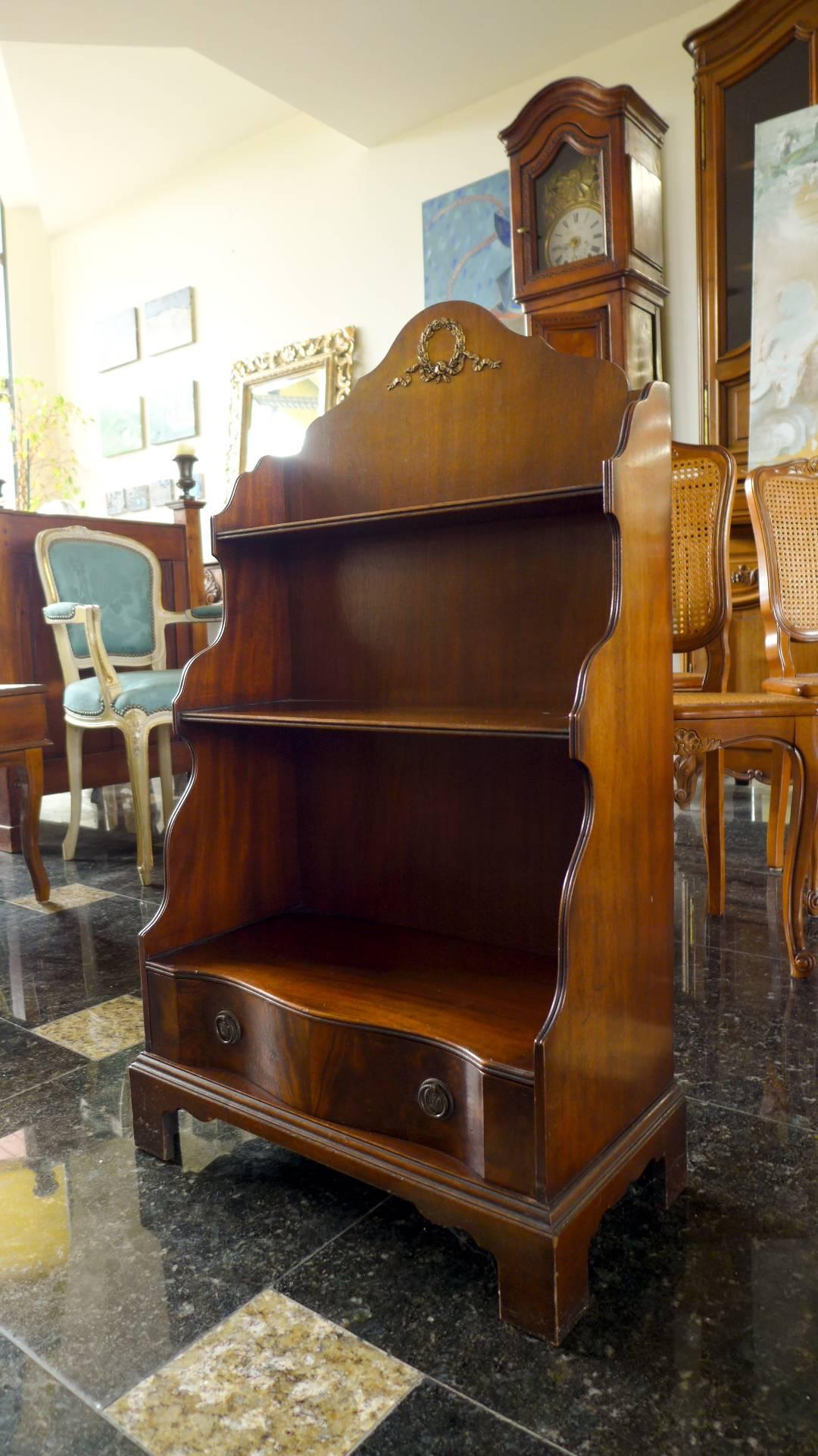 An early 19th century Regency period mahogany waterfall bookcase, having shaped sides and three open shelves with a large drawer beneath.
England, circa 1820.