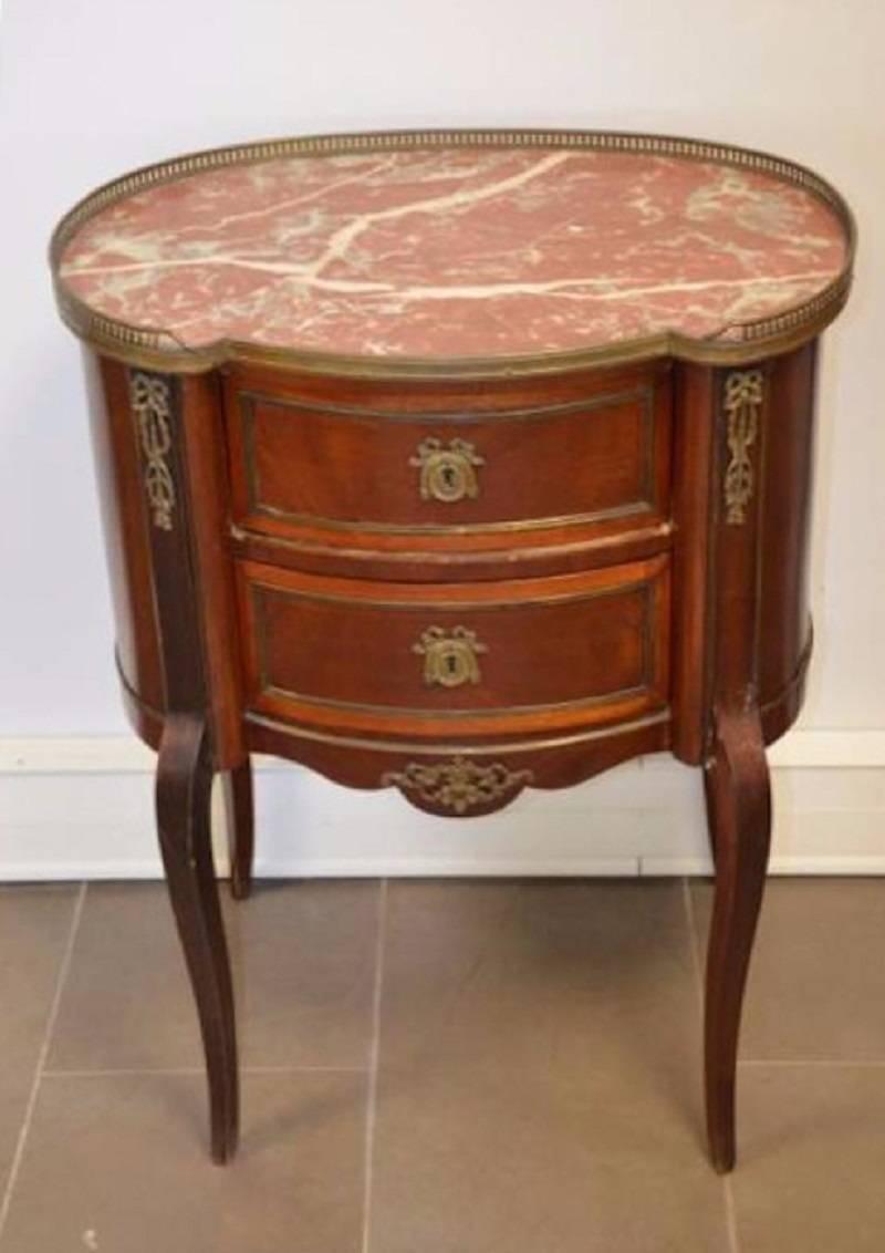 This 19th century French elegant mahogany commode feature red marble-top surrounded with brass decoration, over two bookmatched veneer drawers; raised on cabriole legs,
circa 1860.