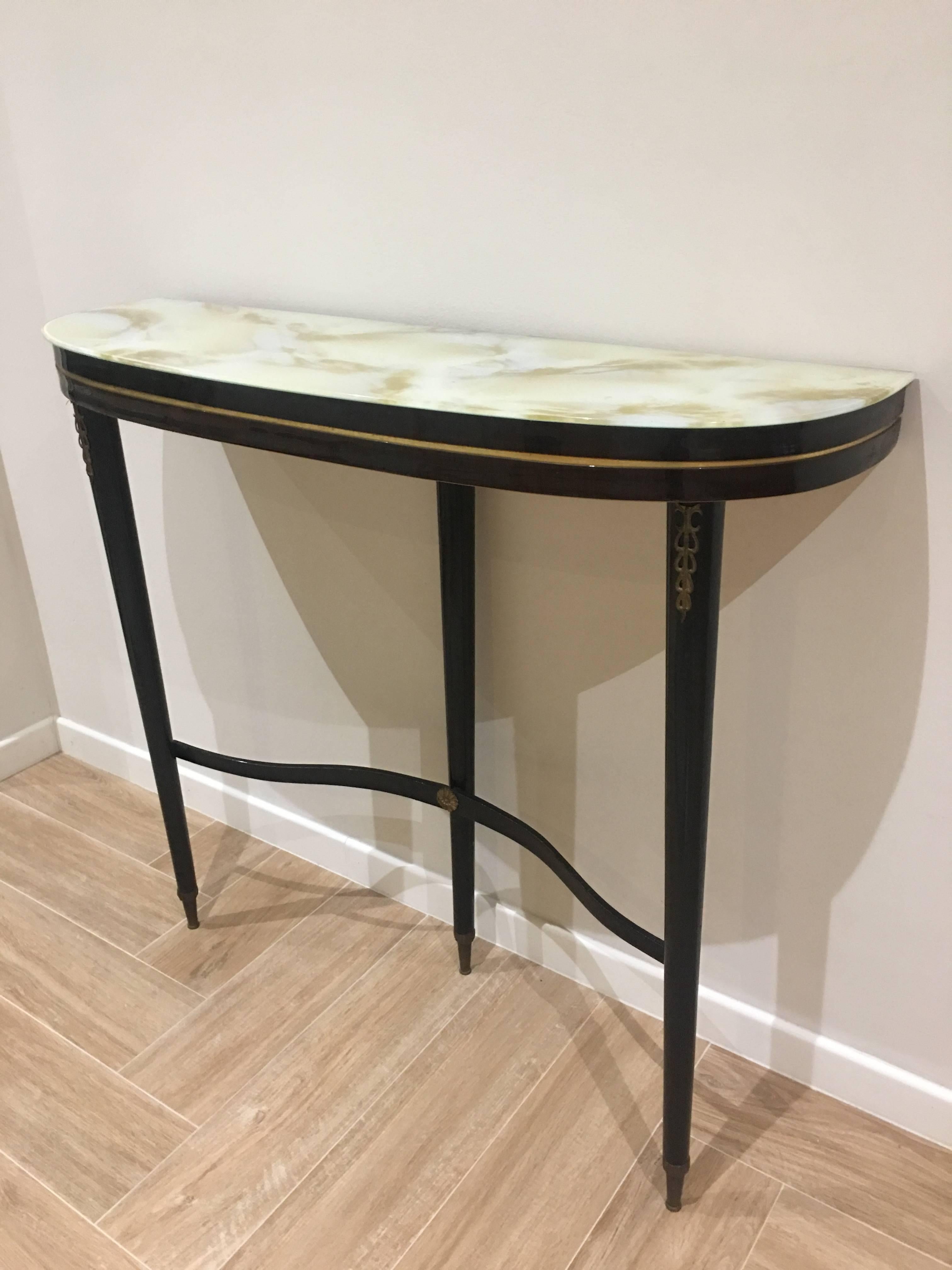 An elegant demilune console from Italy. The top, a thin slice of glass perching upon the lean wooden legs. 
A perfect solution for an entryway, foyer.