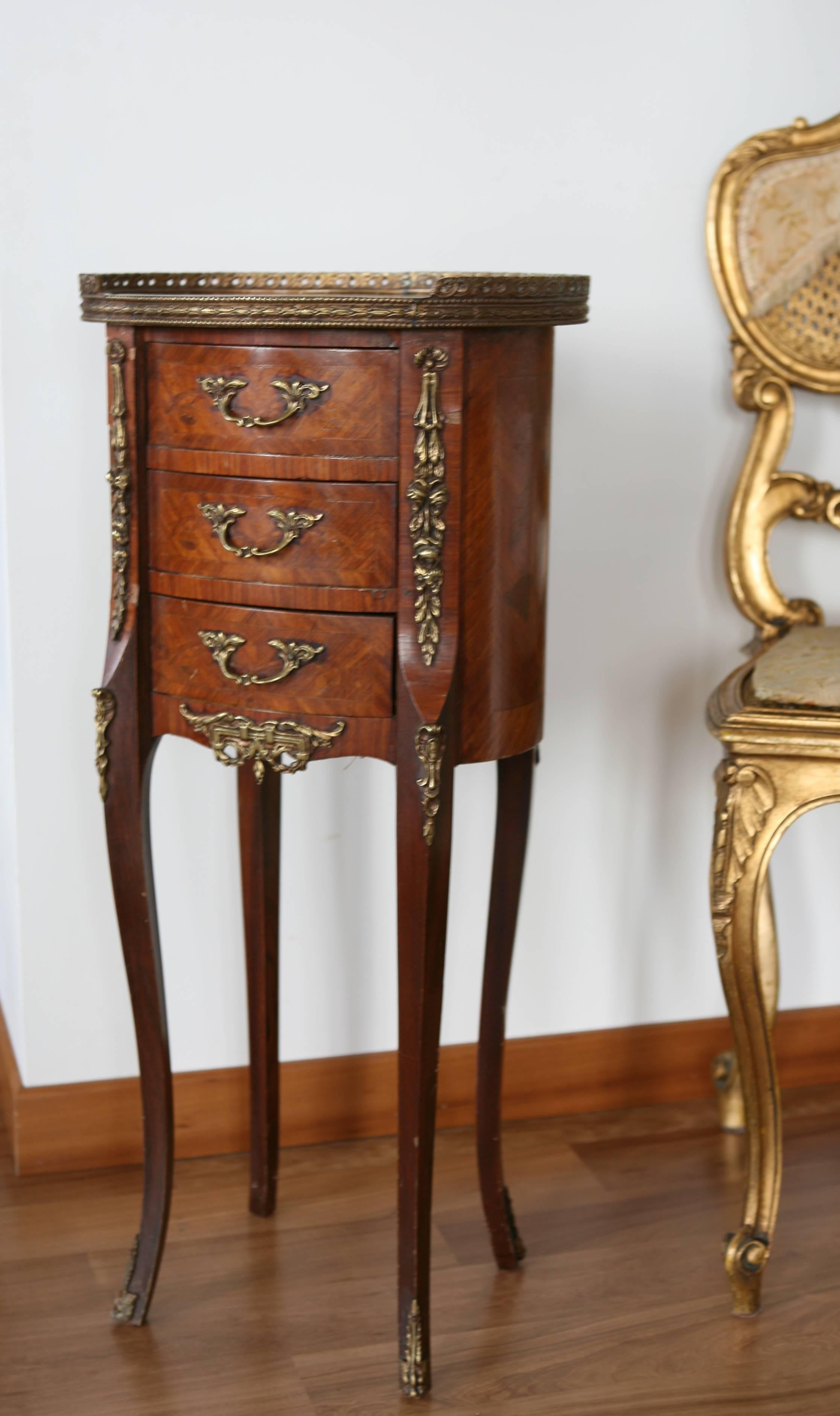 19th century French Louis XV style marquetry side table with three elegant drawers and bronze decoration, resting on long legs.
France,
circa 1830.