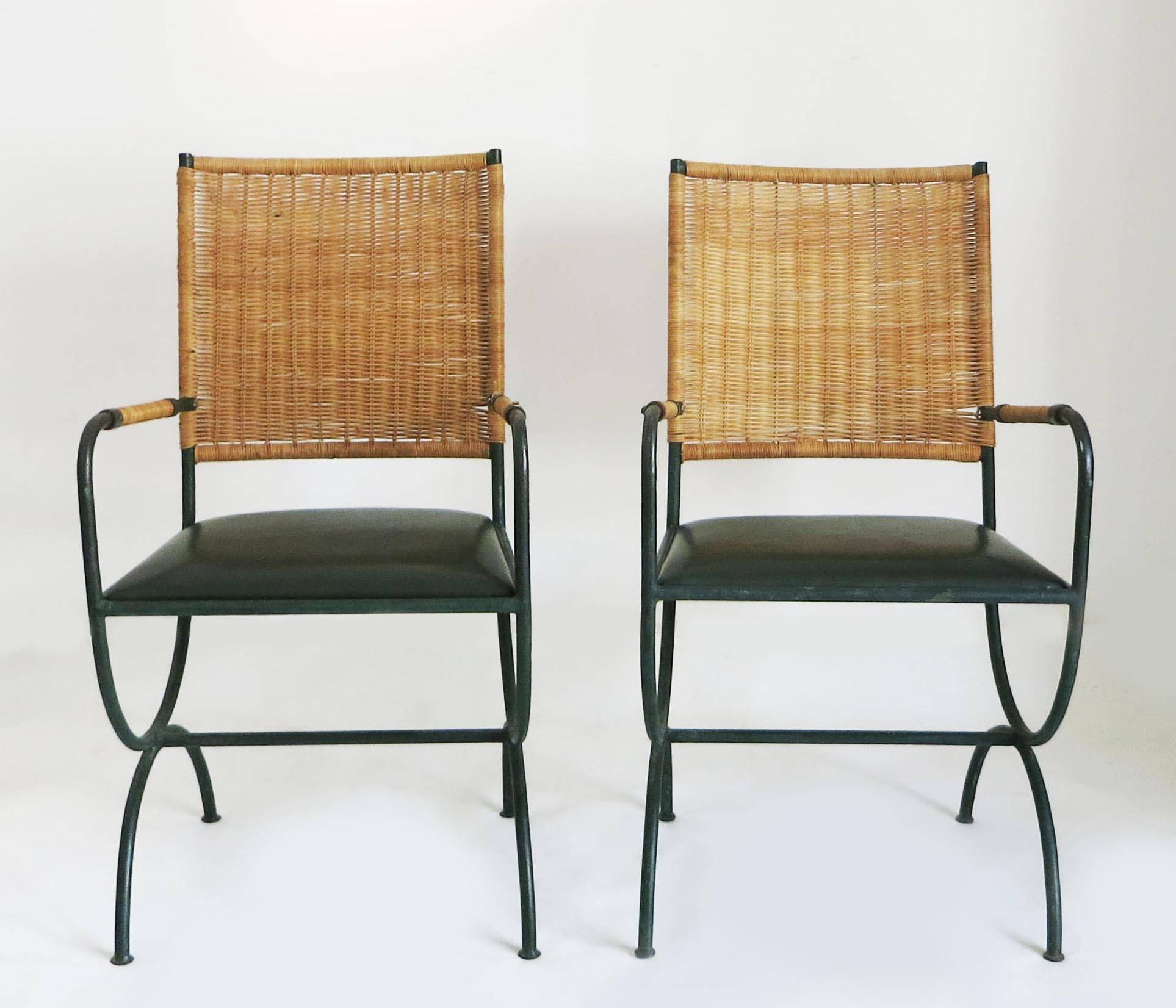 Pair of chairs by Jacques Adnet.
Back and arms in wicker and leather on a dark green iron frame.