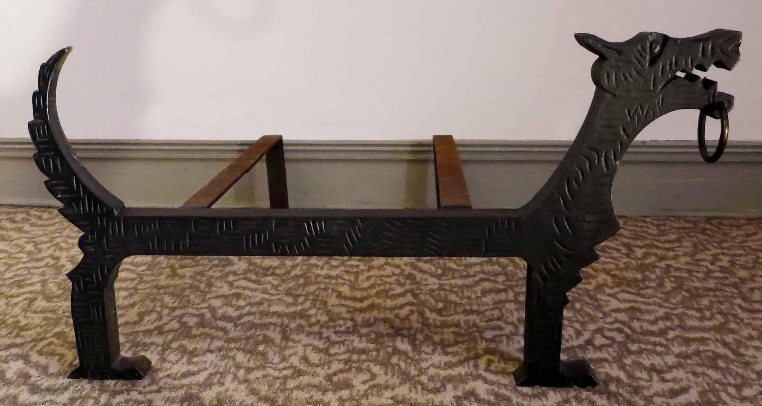 Decorative andiron looking as a dog with a brass ring in mouth.
Cast iron is carved with geometrical design recalling the dog fur.