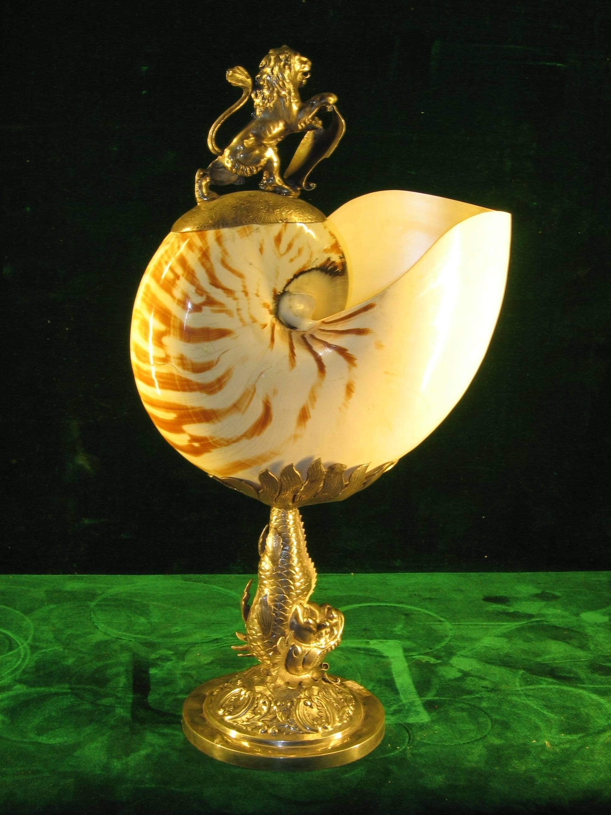 Nautilus mounted in silver of the 19th century (Shell Nautilus)
The support consists of a sea monster resting on a round base, the nautilus being surmounted by a lion resting on a leather engraved with coats of arms of the Polish family