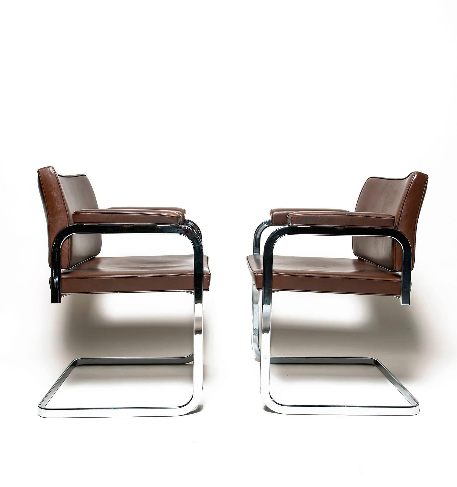 A pair of Bauhaus-style cantilever chairs by Swiss architect and designer, Robert Haussmann. Similar to his Unesco chair design, this pair feature smooth leather upholstery on a polished chrome base. Excellent vintage condition with minimal marks of