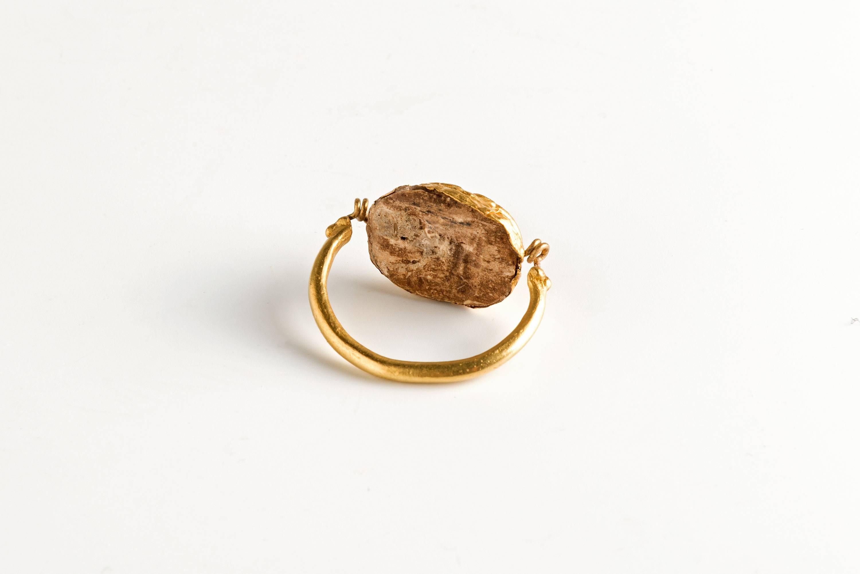 Finger ring in 22-karat gold with a swivelling scarab bezel in a golden leaf of 24-karat gold. Phoenician, circa 1400 BC.
The steatite scarab shows a sphinx. This ring is fragile but wearable and has Museum quality.
Accompanied by a certificate of