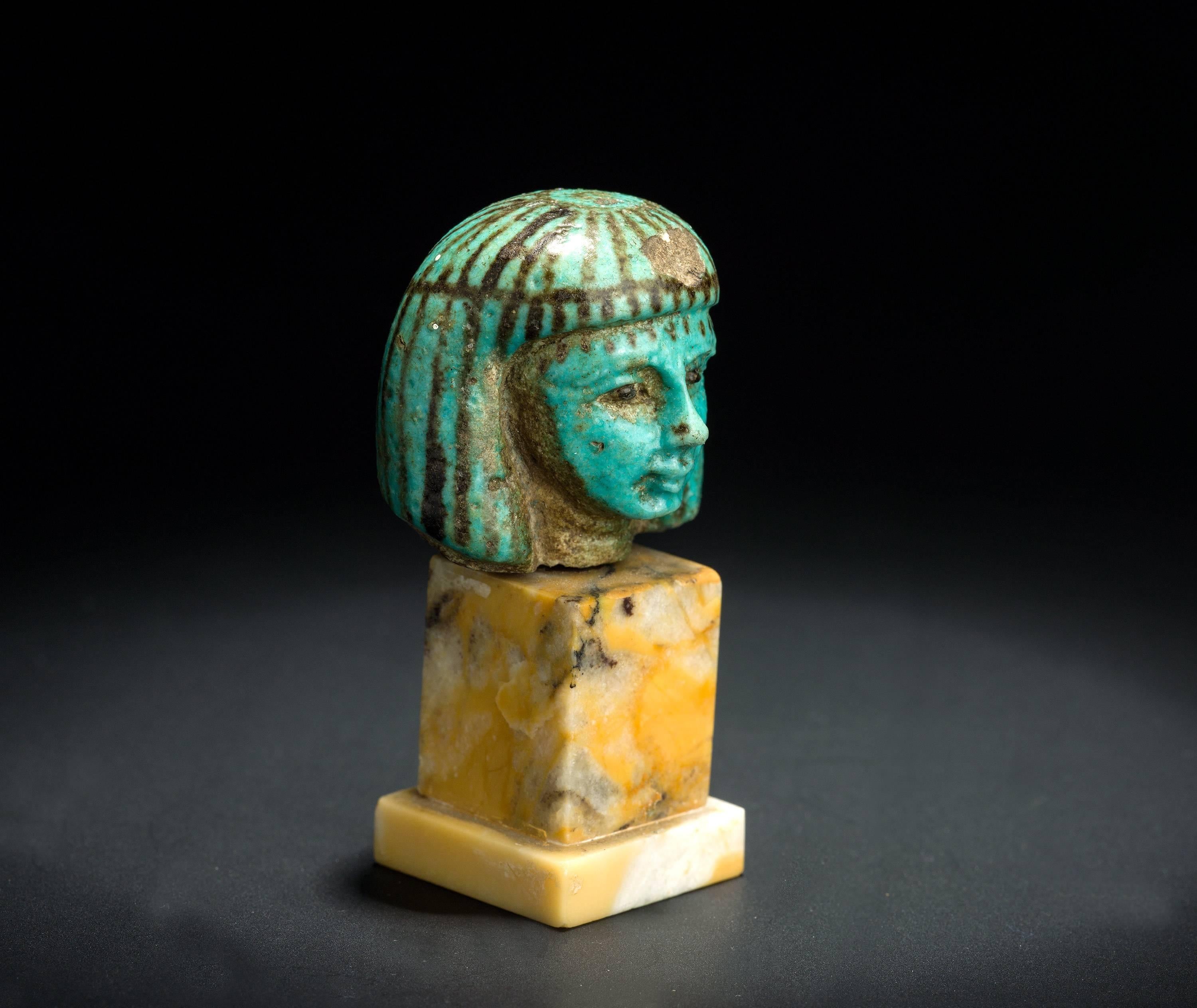 The small head has unusually fine worked out features that definitely appear female. It is unlikely therefore, that it belonged to shabti. More likely it once formed part of a concubine figure or perhaps of a cosmetic spoon, of the so-called