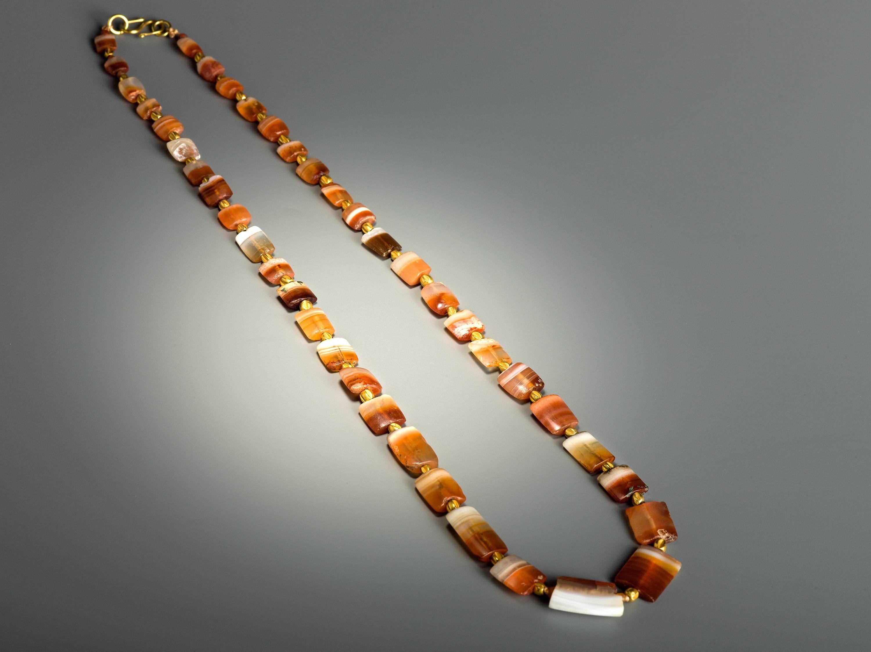 This very attractive necklace is composed of 41 rectangular Agate beads interspersed with gold melon beads. 
A unique piece of ancient jewellery, the necklace is restrung and wearable. 
Provenance: Private collection Switzerland.
Accompanied by a