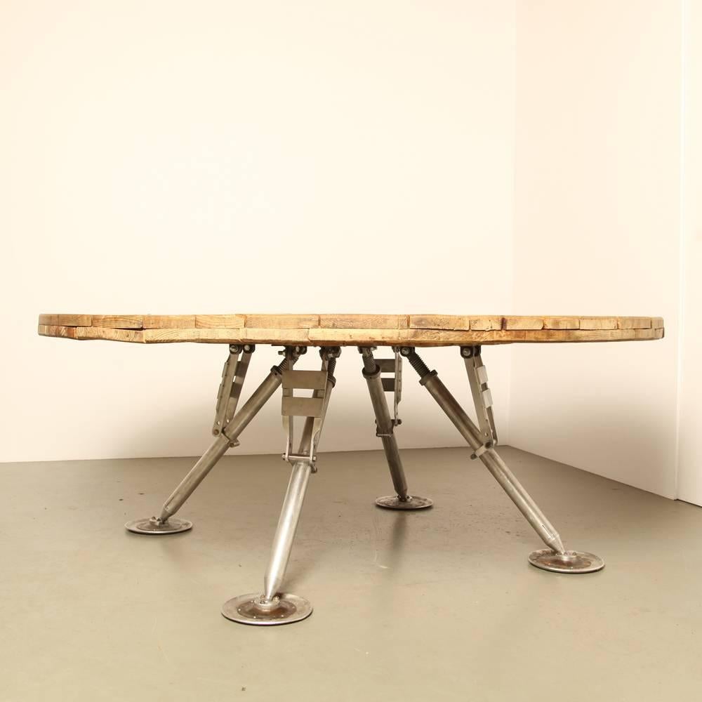 Industrial raw wood table with Space Age legs.

The legs are adjustable; by changing the angle the height can be adjusted up to 85 cm high.

Excellent affordable worldwide shipping available.