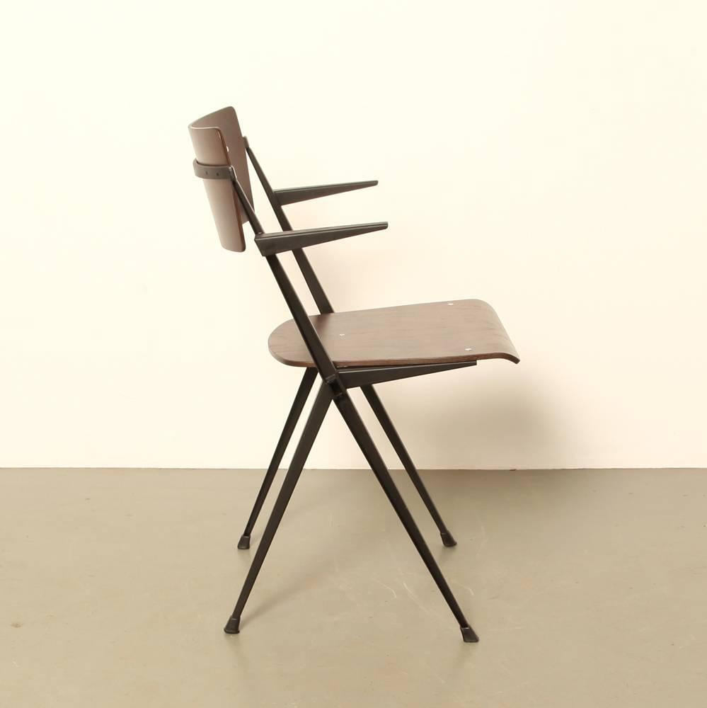 Name: Pyramide Chair
Designer: Wim Rietveld
Manufacturer: Ahrend de Cirkel NL
Design year: 1959

Stackable

Industrial school chair

Dark brown bent plywood seat and back

Original black frame from the 1960s, from the technical school in
