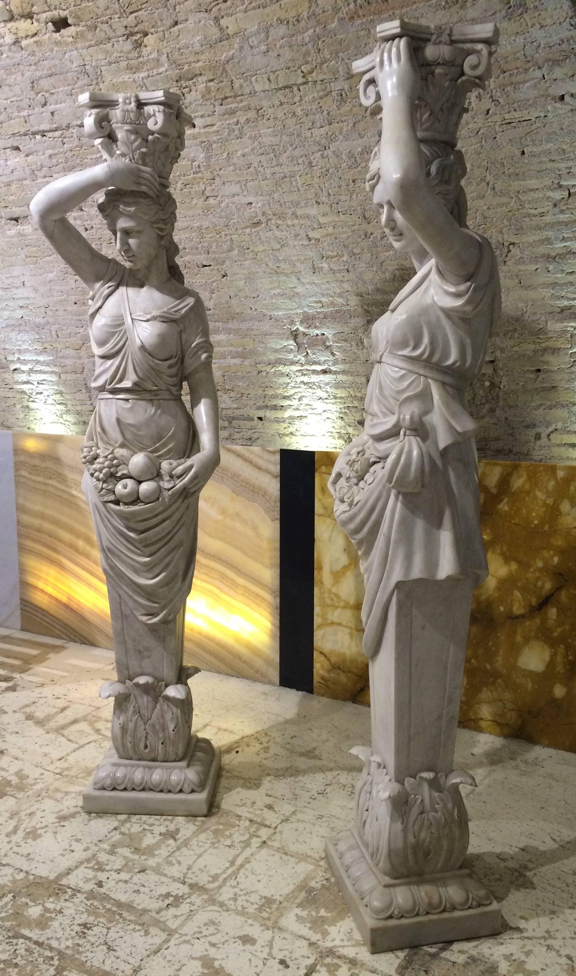 A pair of superlative italian caryatids carved in white marbles; the caryatid is female figure serving as an architectural support taking the place of a column or a pillar supporting an entablature on her head. The Greek term karyatides literally