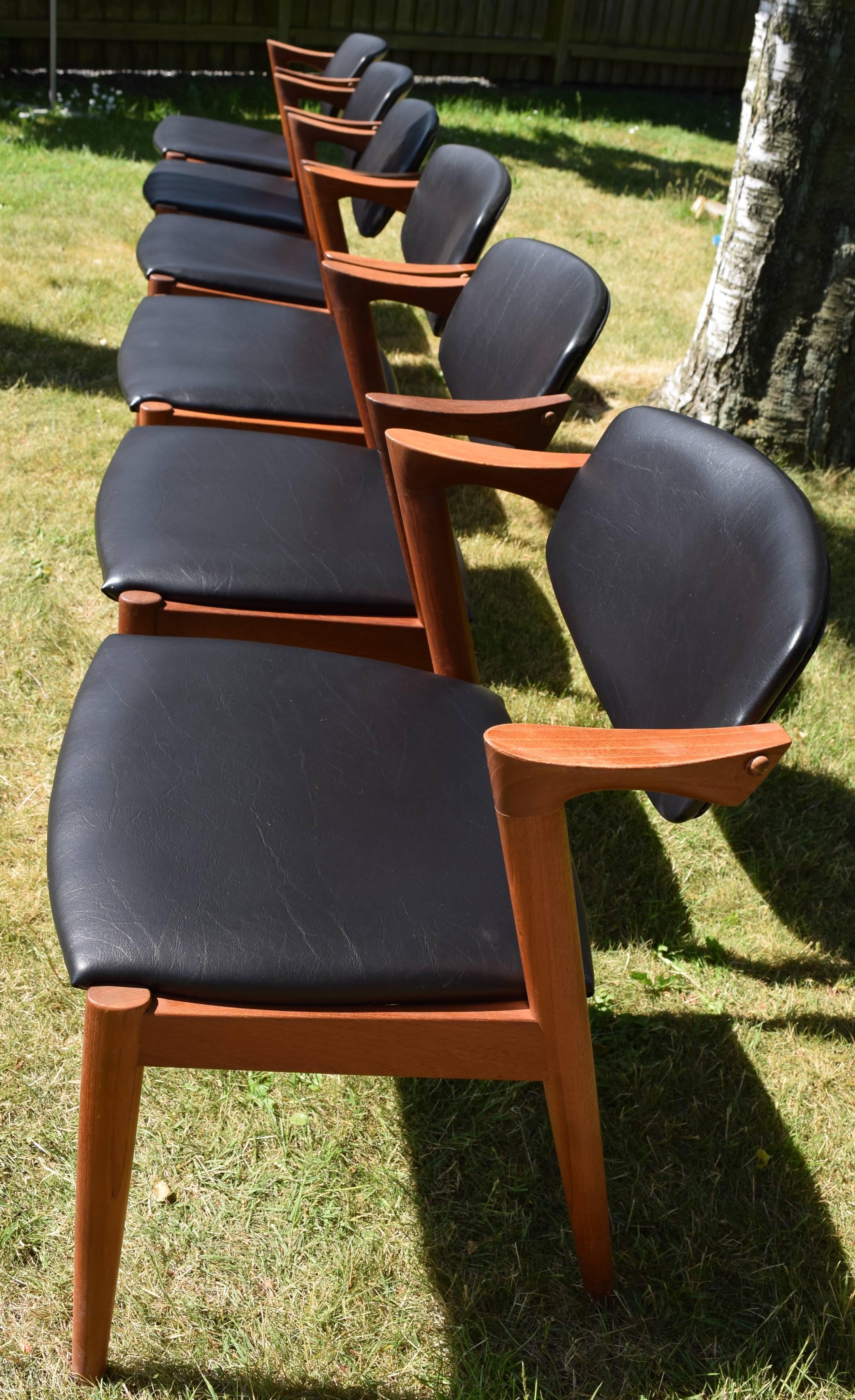 This set of six teak dining chairs was designed by Kai Kristiansen in the 1950s for Schou Andersen Møbelfabrik. These chairs have been recovered with black leatherette.