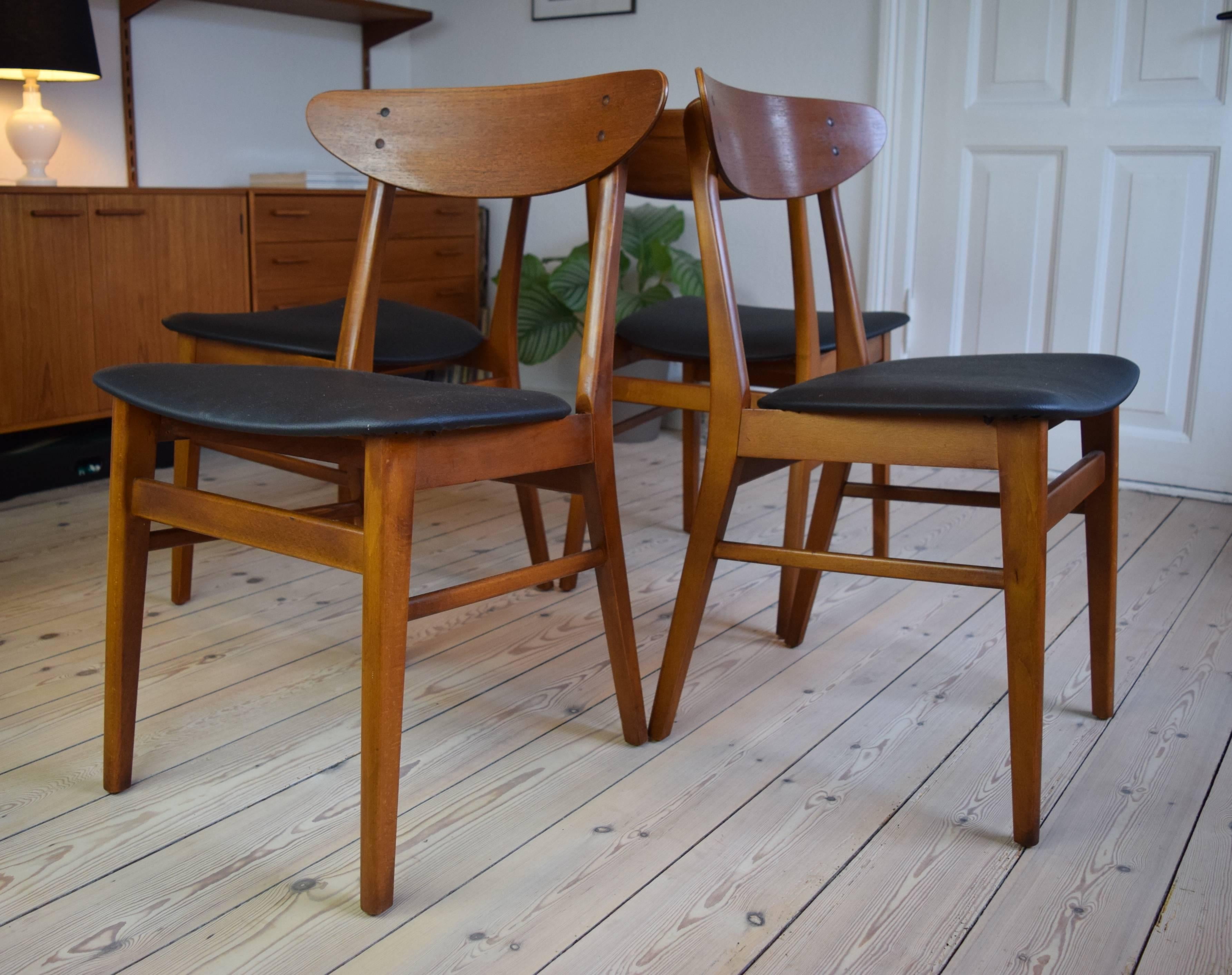 Set of four model 210 dining chairs by Farstrup manufactured in Denmark in the 1960s. These chairs feature beech frames with curved teak backrest, and are covered with black nappa.