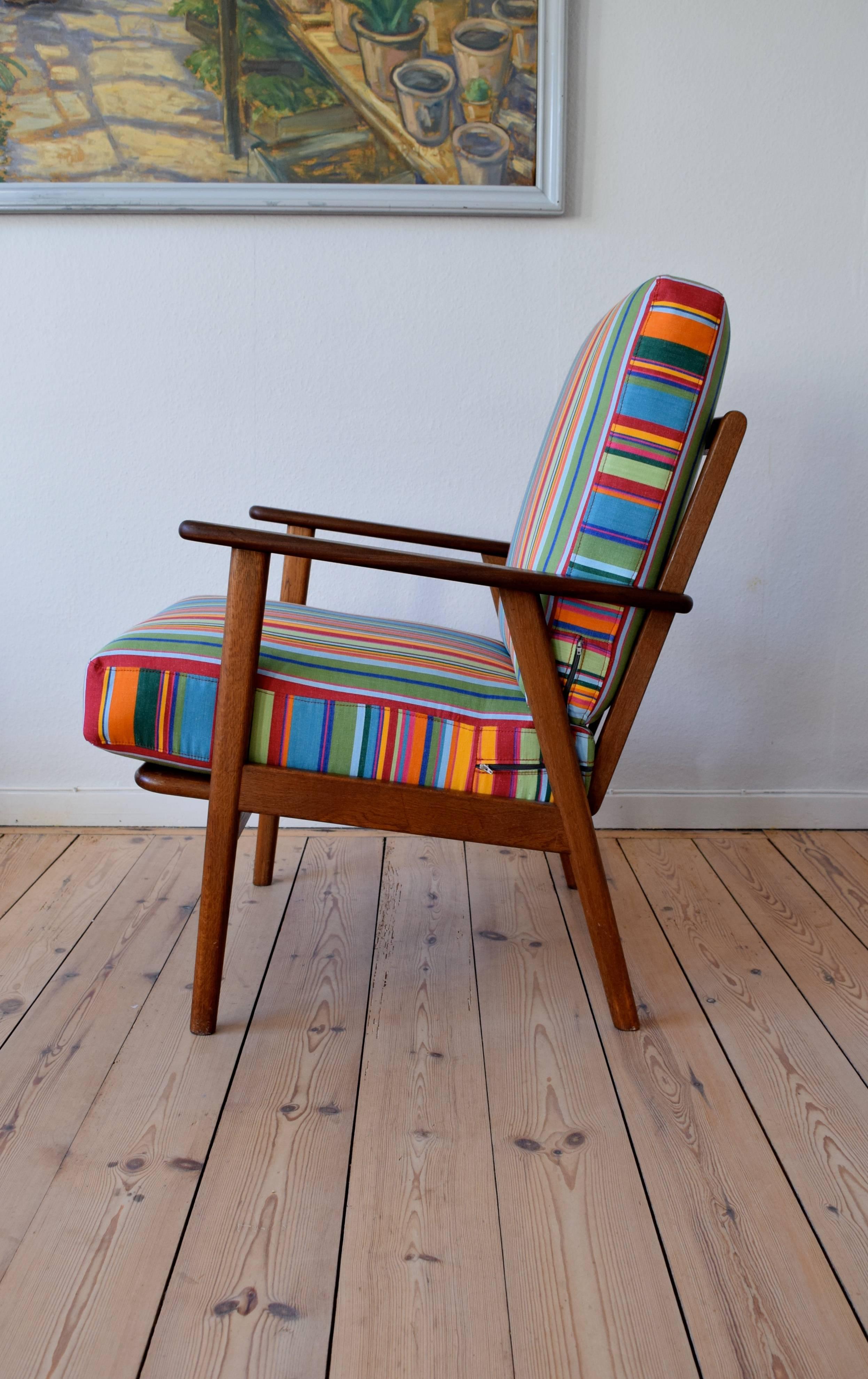 Teak and oak easy chair for the 1960s manufactured in Denmark. This item features new webbing and original sprung cushions with multi-colored fabric from the 'Stripes Company'.