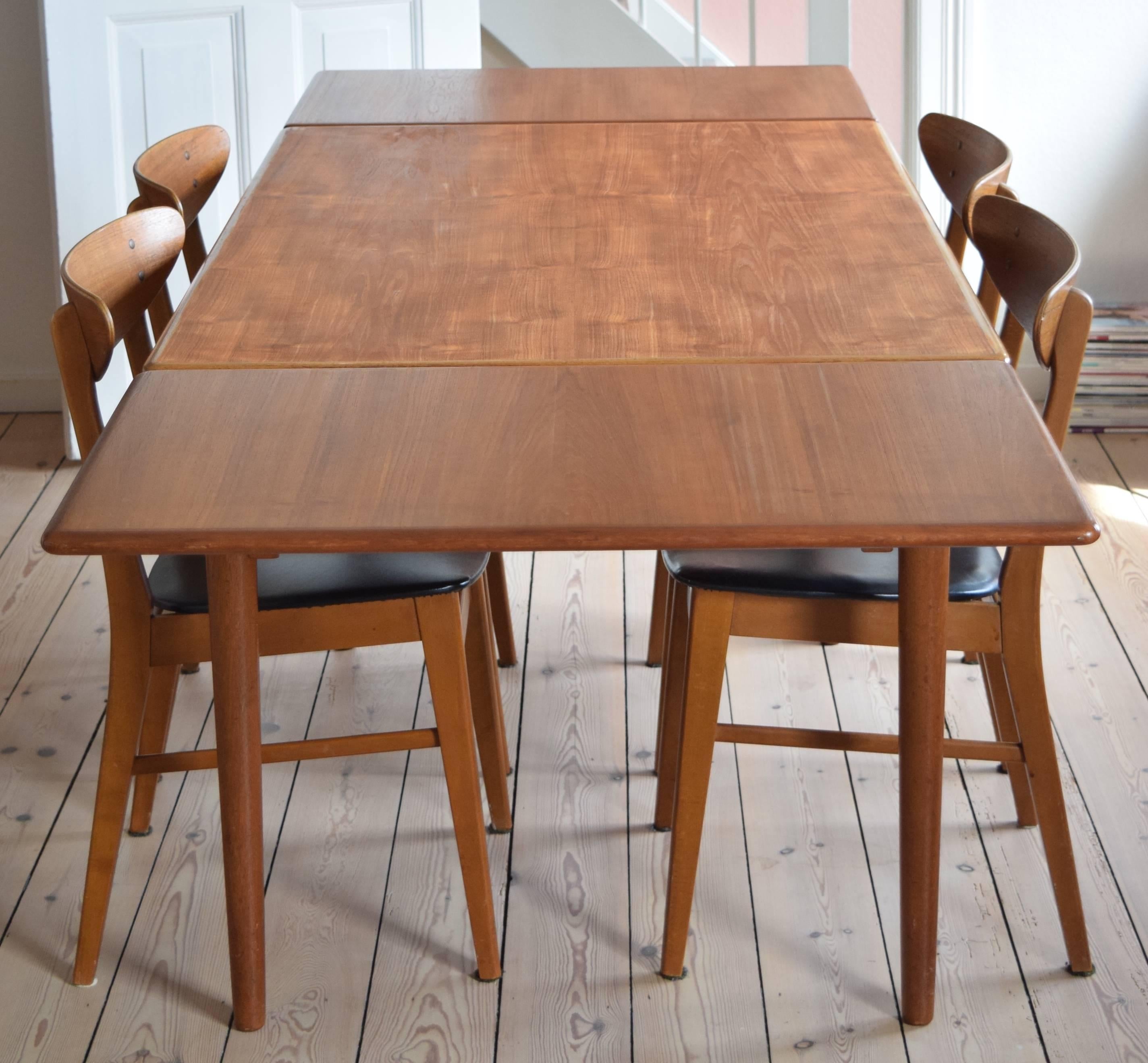 A beautiful extending teak dining table manufactured in Denmark in the 1960s. This item features solid bevelled teak edge and legs, and has two hidden plates which can be used to extend the table length to 238.5cm allowing for ten people to sit