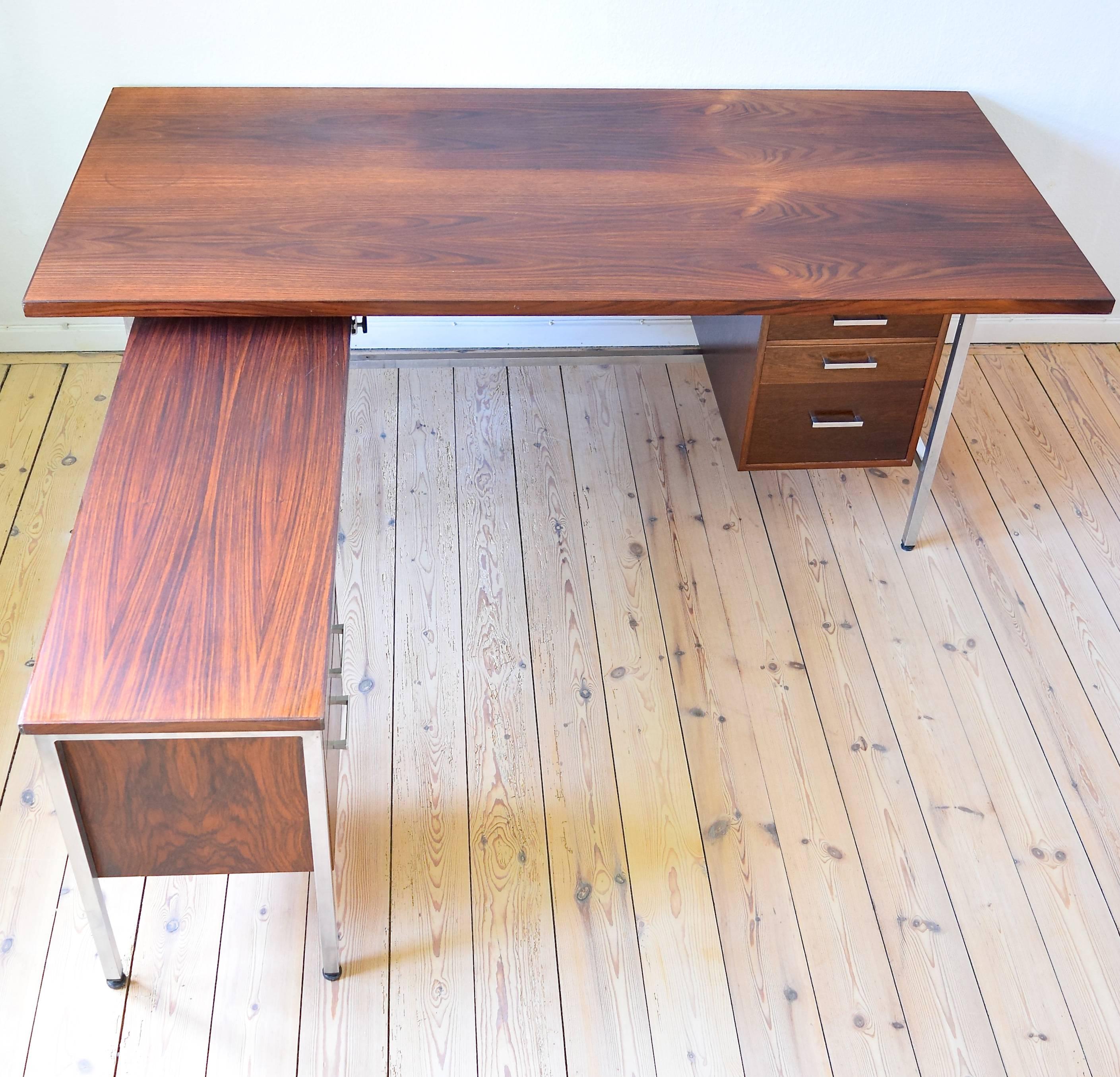Executive chrome and rosewood desk from the 1960s. This item features two sections, one with two drawers, the other with three. The shorter end can be moved to sit at the opposite side of the desk. Deep rosewood grain throughout the two top-plates.