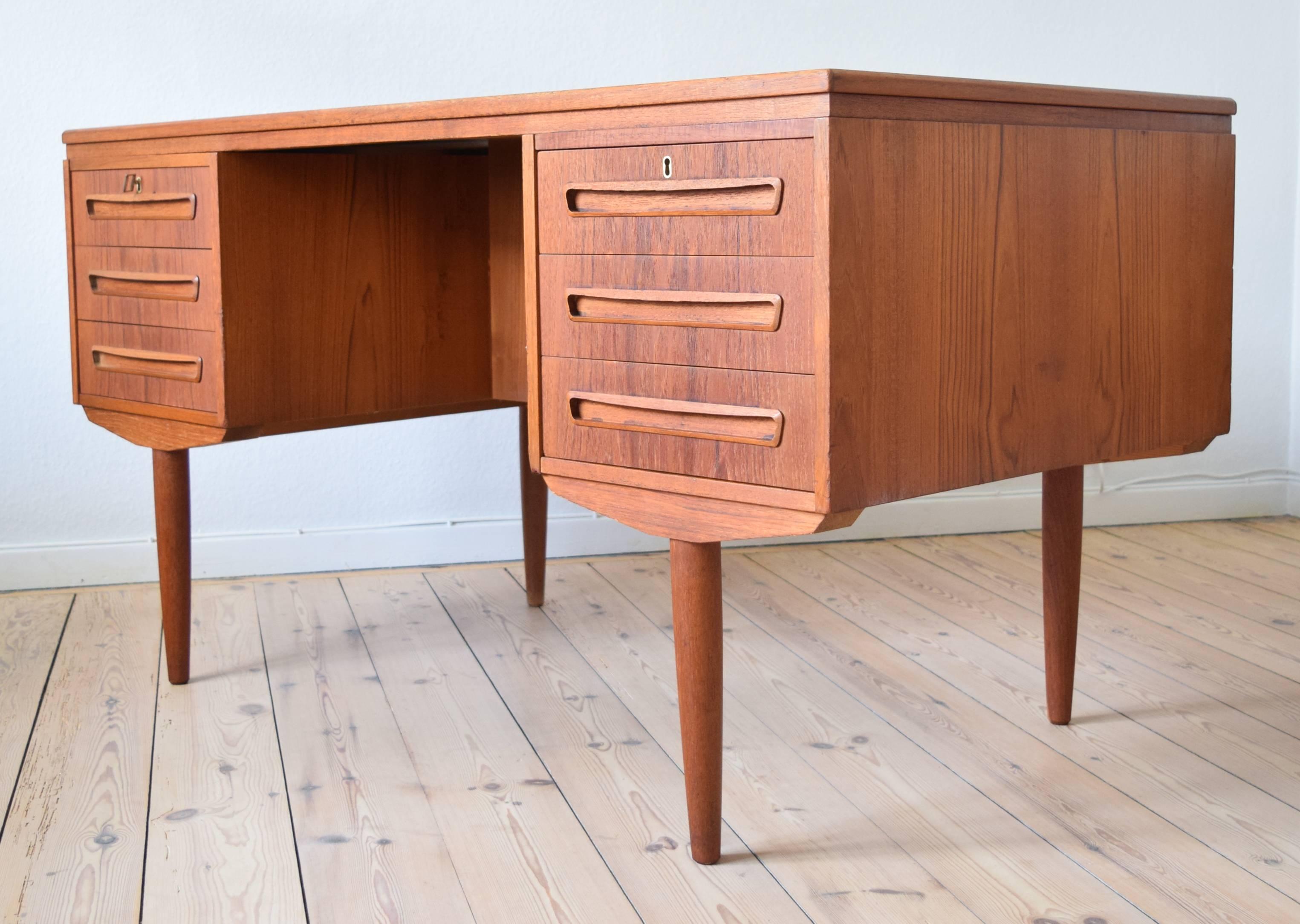 Teak desk designed by J. Svenstrup for A.P. Møbler, Denmark in the 1960s. Desk features six drawers (two lockable) on the front, and bar cabinet on the back side. Some small marks here and there commensurate with age and usage, but overall this