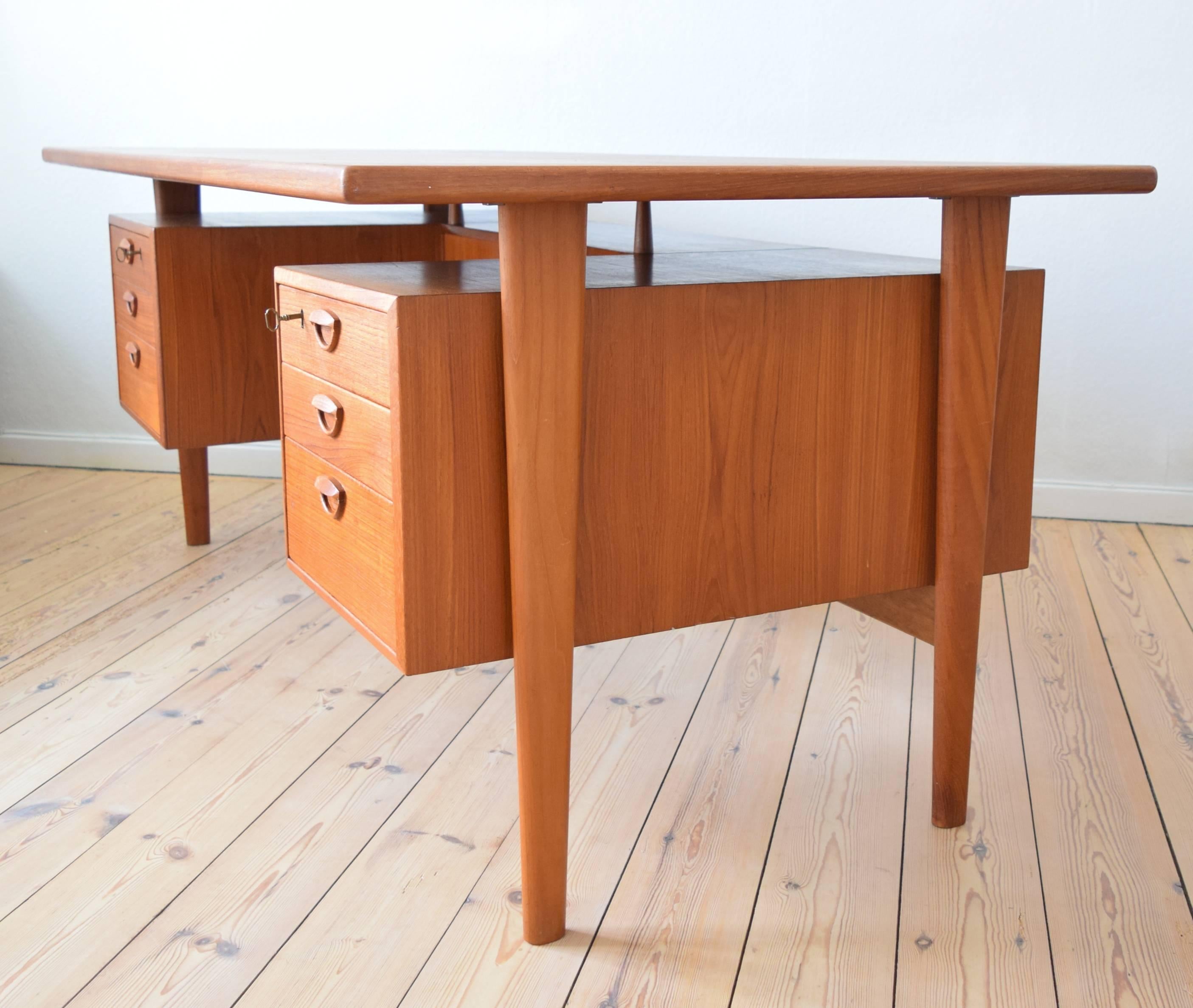 This is one of the largest desks designed by Kai Kristiansen and has a total width of 179 cm. Manufactured by Feldballes Møbelfabrik it features six drawers on the front and on the back, two lockable bar sections plus bookshelf. The desk has been