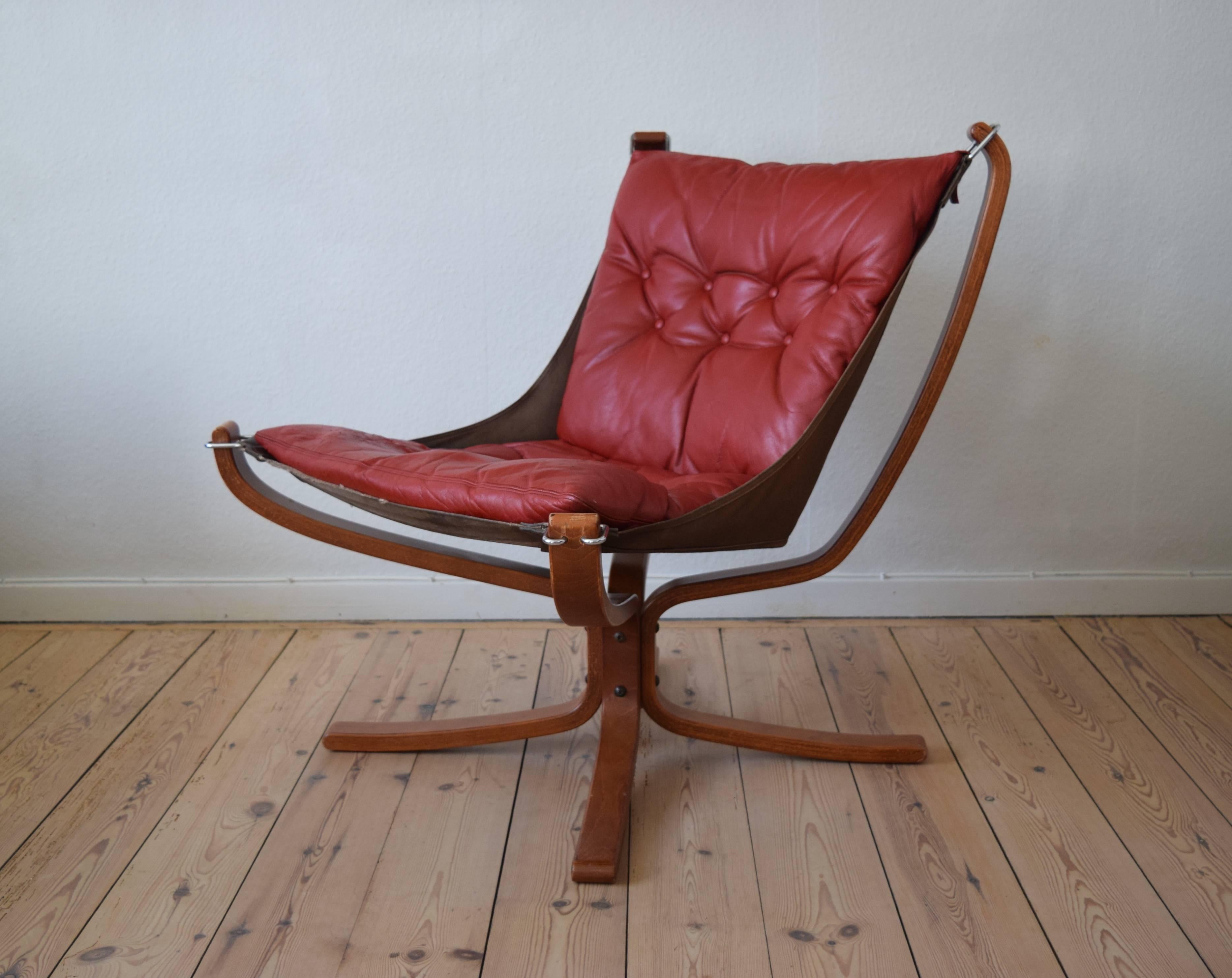 A low back falcon chair designed by Sigurd Ressell and manufactured in Denmark in the 1970s. The chair features a bent beechwood frame, with a red leather cushion.