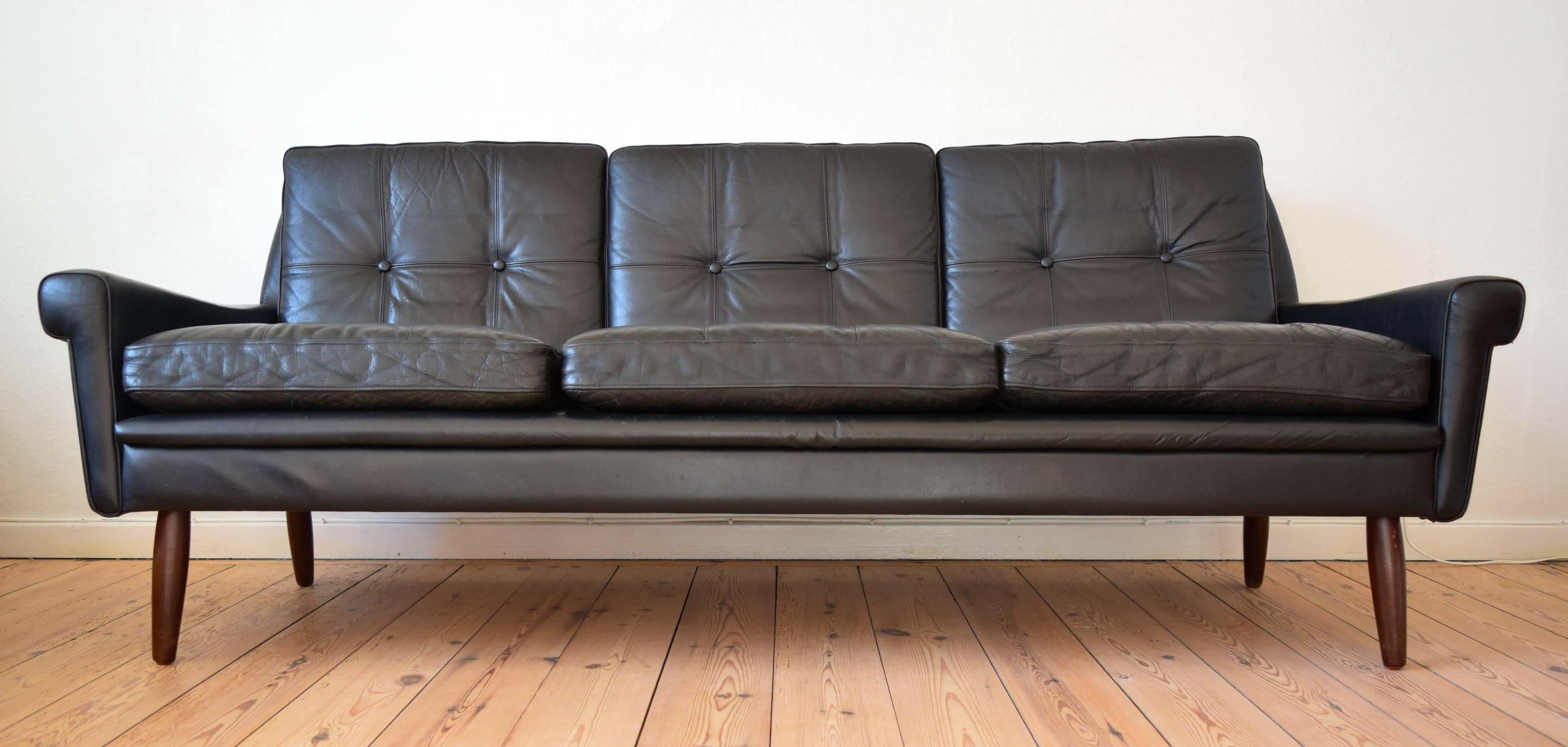 Elegant three-person sofa manufactured in Denmark in the 1960s by Skipper Møbler. Features buttoned cushions which are still firm with just the right amount of patina. Sits on turned teak legs.