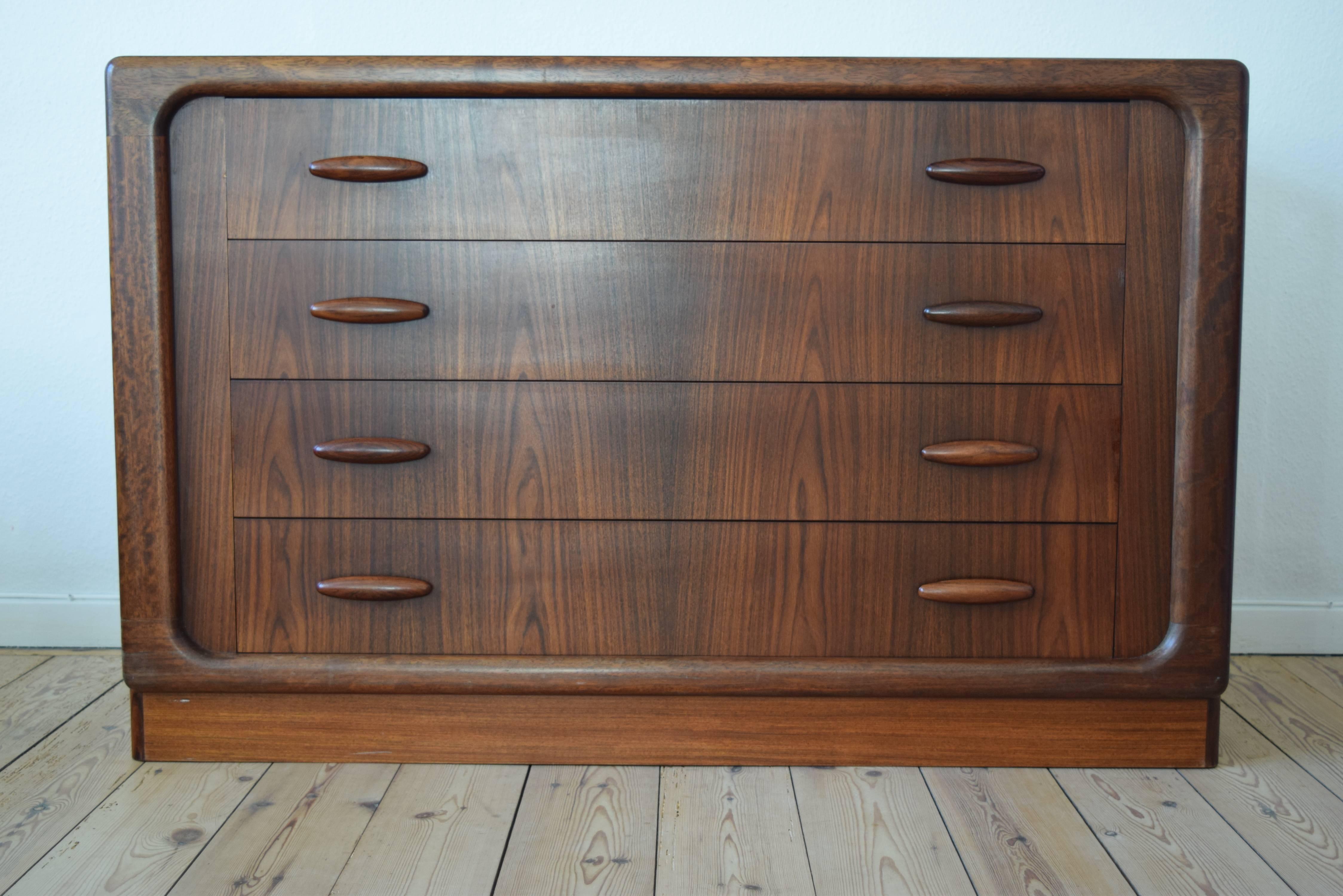 This large rosewood chest was manufactured by Dyrlund in the 1960s. This piece features four drawers with sculpted rosewood drawer pulls. The four drawers have a solid teak interior as does the interior of the chest. Bevelled front edge. The weight