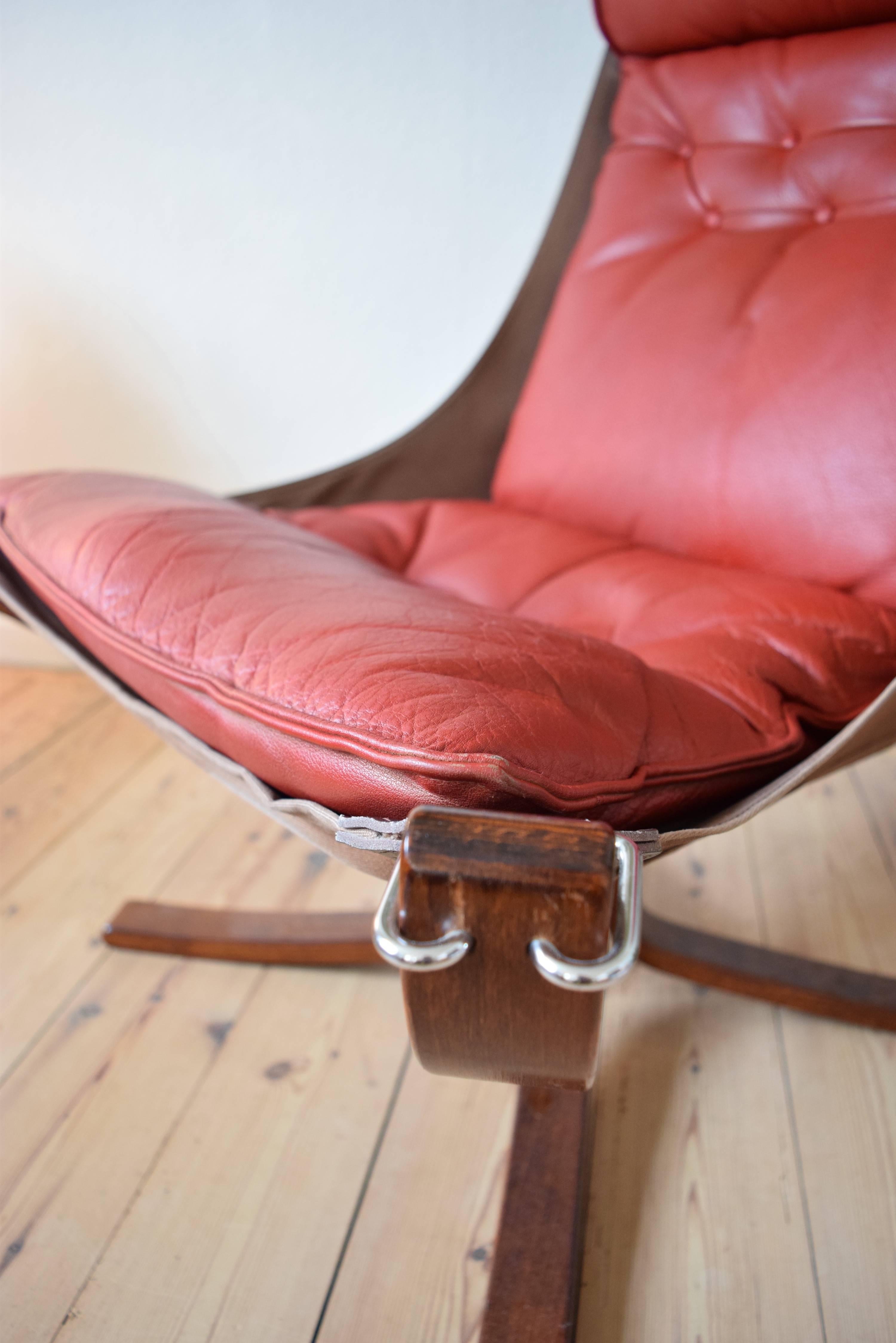 Falcon chair designed by Sigurd Ressel and manufactured by Vatne Møbler in Norway in the 1970s. Features red leather cushion and sits on a canvas hammock. With original receipt.
