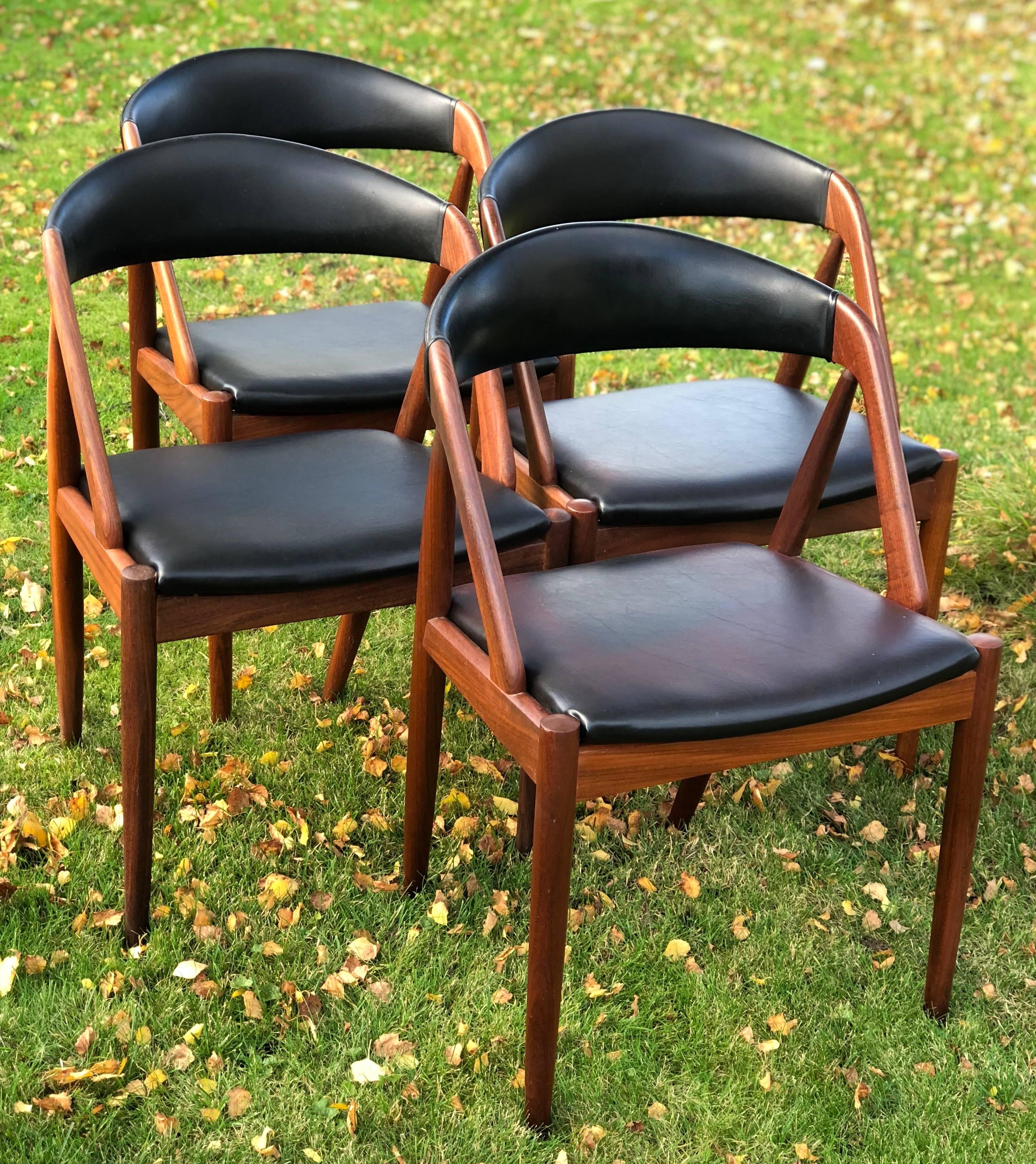 Set of four dining #31 chairs by Kai Kristiansen for Schou Møbelfabrik, Denmark. The frame is made of teak and the seats and backrests are covered in the original black skai. Seats have been recovered more recently. This model features a deep curved