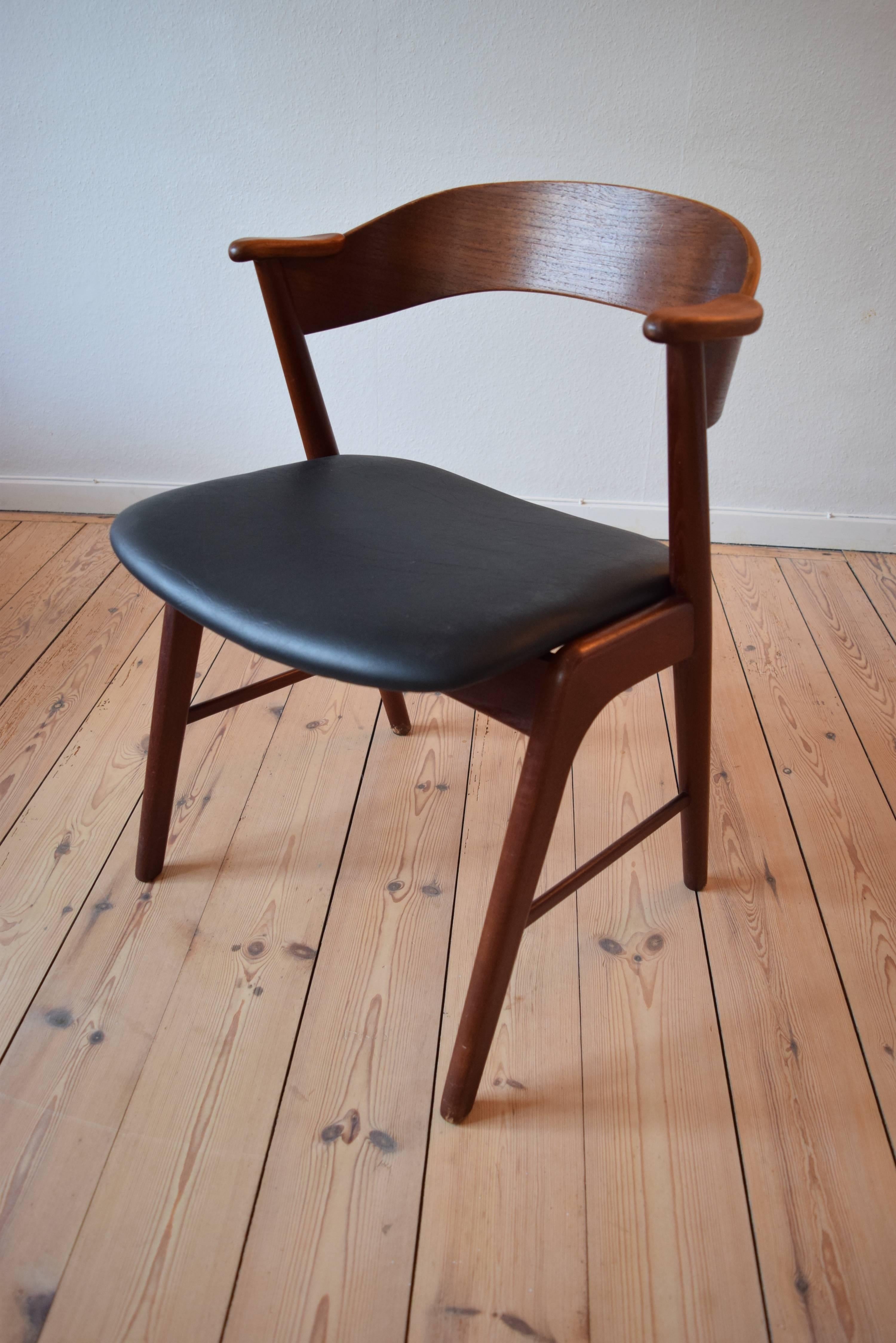 Vintage teak armchair designed by Kai Kristiansen for Kørup Møbelfabrik, Denmark in the 1960s. Features curved backrest and teak armlets. Newly recovered with high quality thick black Skai.