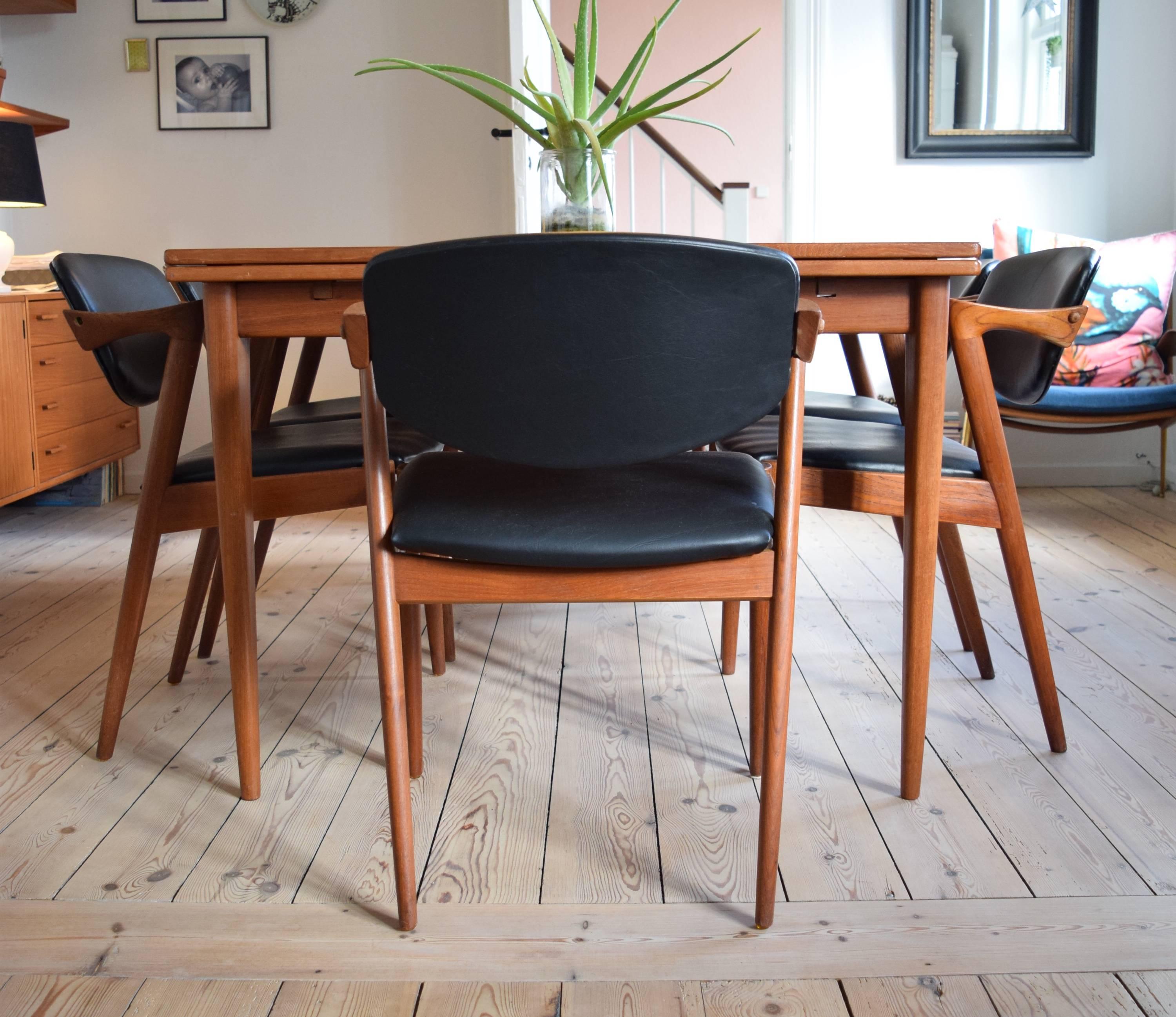 A set of six Kai Kristiansen model 42 teak dining chairs, manufactured by Schou Andersen in the 1960s. These chairs are covered in black leatherette. Chair frames have been re-finished, cleaned and oiled. Some small marks here and there commensurate