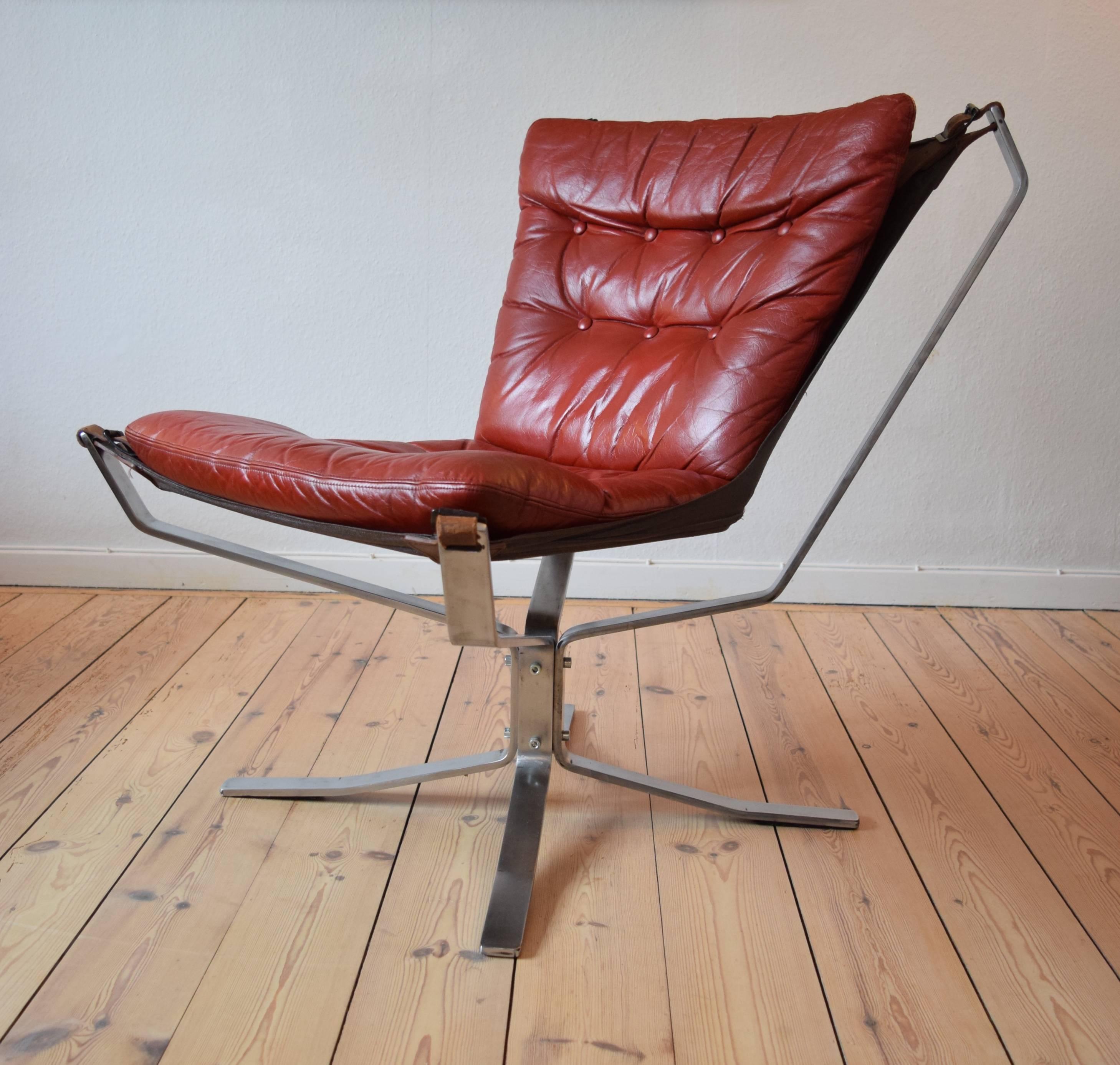 Chrome base Falcon chair designed by Sigurd Ressell and manufactured in Denmark in the 1970s. Features red leather cushion and sits on a vinyl hammock. Apart from some minor marks here and there this item is in a very good vintage condition. Legs