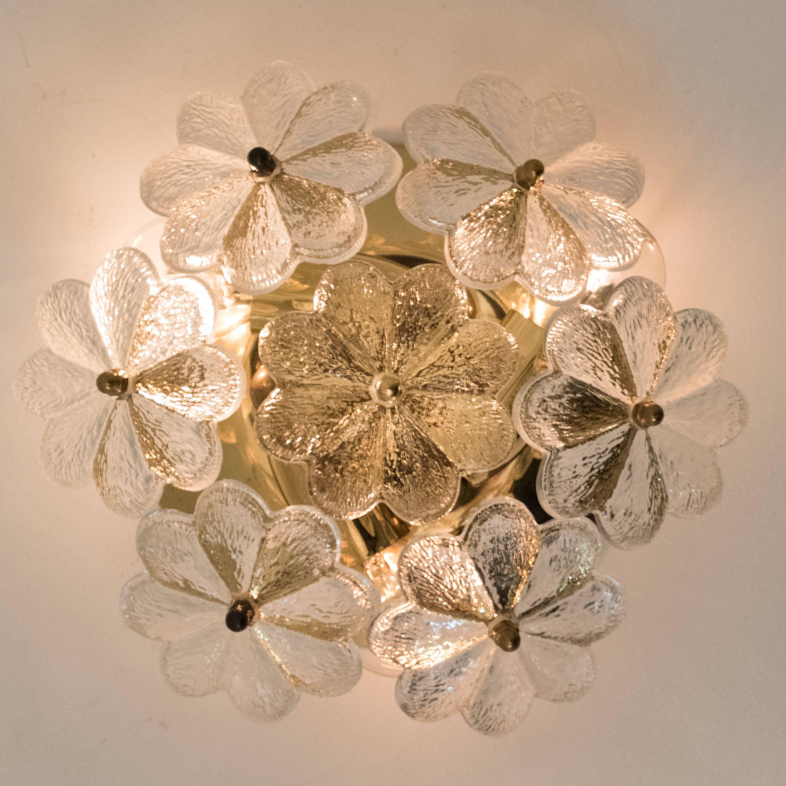 These sculptural wall sconces have the design of a bouquet of textured glass flowers and are from the historical lighting company Ernst Palme. Each light has seven glass shades. Flower shaped.

Each clear glass flower shade has textured petals and