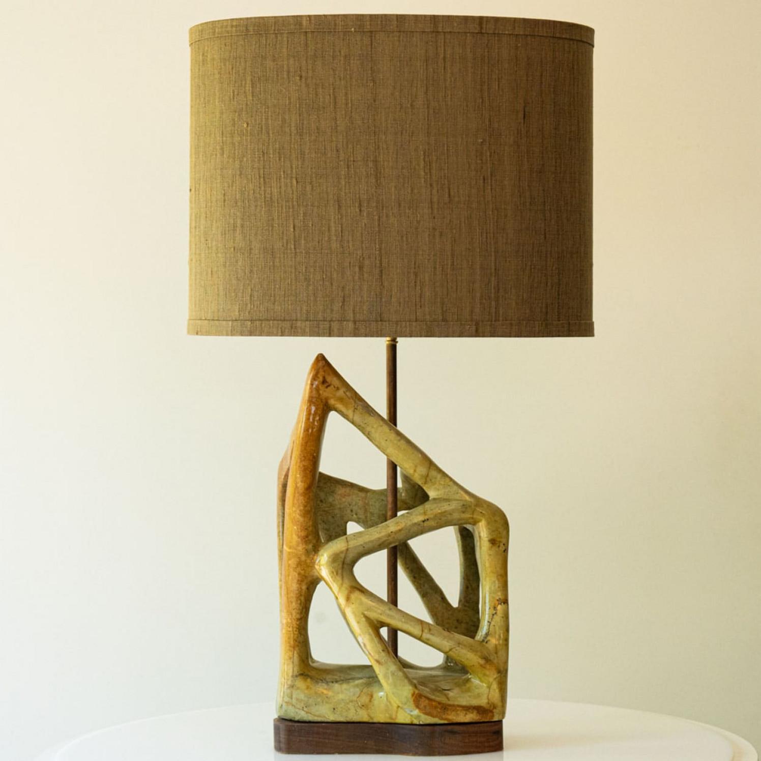 Beautiful serpentine table lamp from the 70s.

This stylish serpentine lamp base on walnut wood brings refined elegance and rich visual appeal to any interior. With its geometric shapes and deep, expressive colors, it showcases the enduring beauty