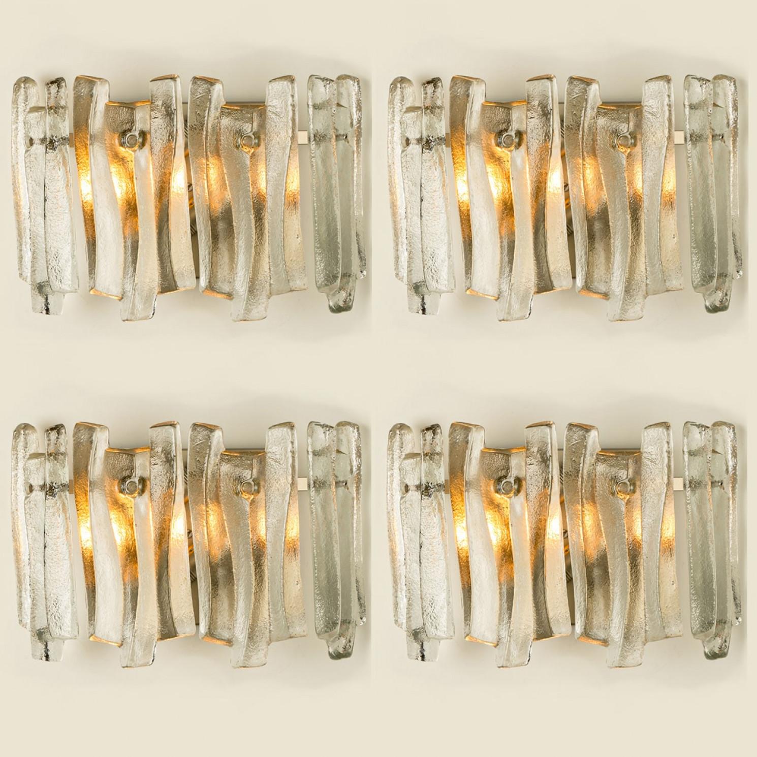 Beautiful and elegant modern wall lights in the style of Kalmar in the 1970s. A lovely design. Twelve thick, textured glass beams in an organic, wave-like shape. The clear glass has an icy, handcrafted look, creating a sculptural and elegant effect.