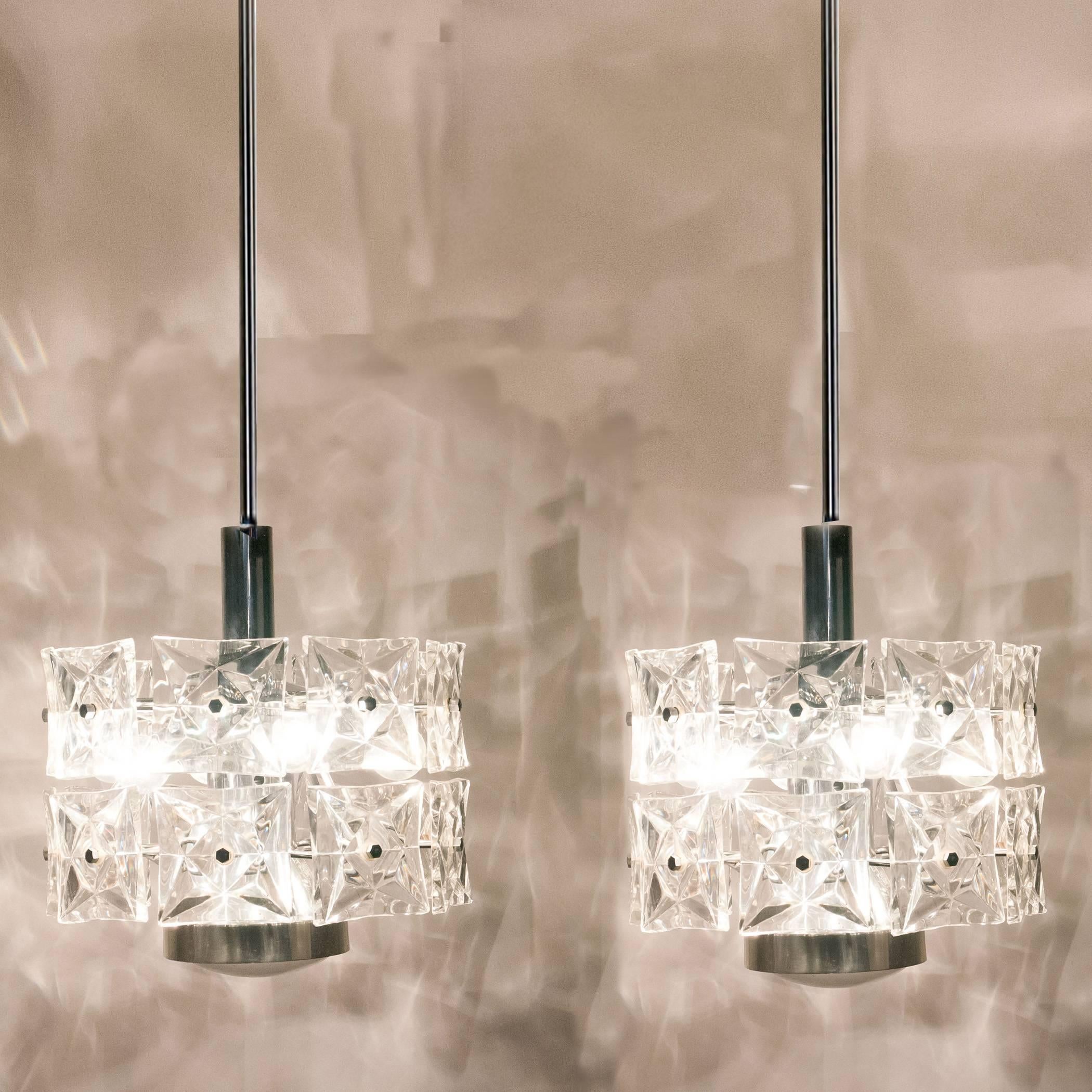 A pair of very modern, elegant and fine Kinkeldey chandeliers. Really heavy quality.They are comfortable with all decor periods. This chandeliers are executed to a very high standard. The quality large square crystals beautifully reflecting the
