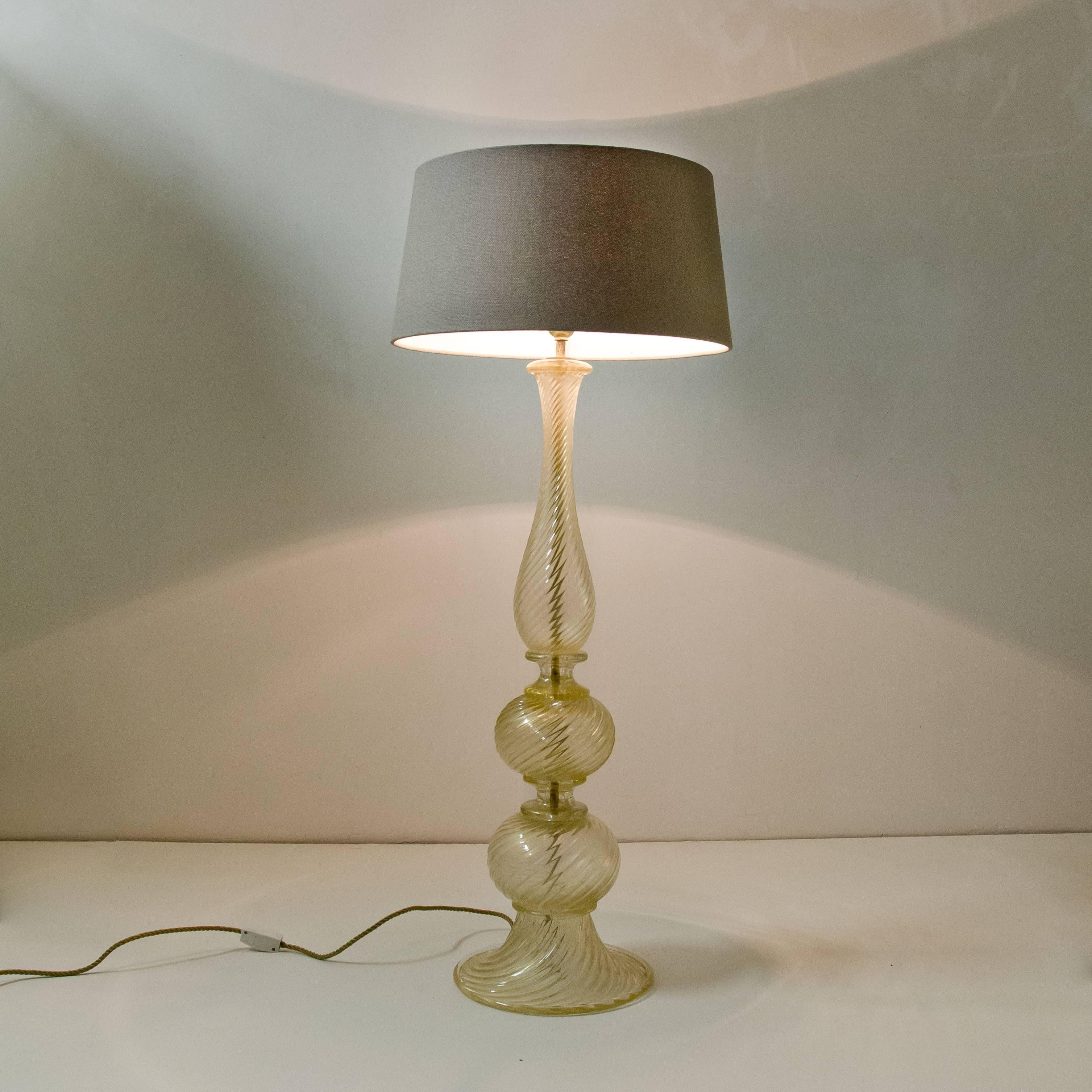 A elegant Italian Murano gold inclusions glass floor lamp by Barovier & Toso. Well-wired with double cluster sockets and French style rayon twisted cord. Shade is included. Typical white glass with gold spangles, for a Baroque shape. 

Length