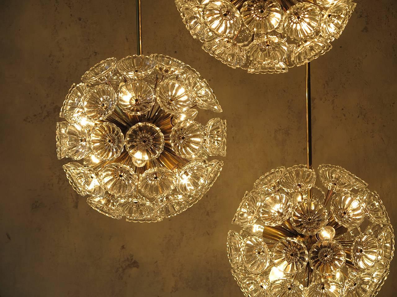 Eye-catching floral glass and brass chandeliers in the style of Emil Stejnar, manufactured in the 1960s in Germany.
Very heavy with glass flowers on a brass Sputnik frame. 
The glass pieces are beautifully cut with a fine eye for detail, all