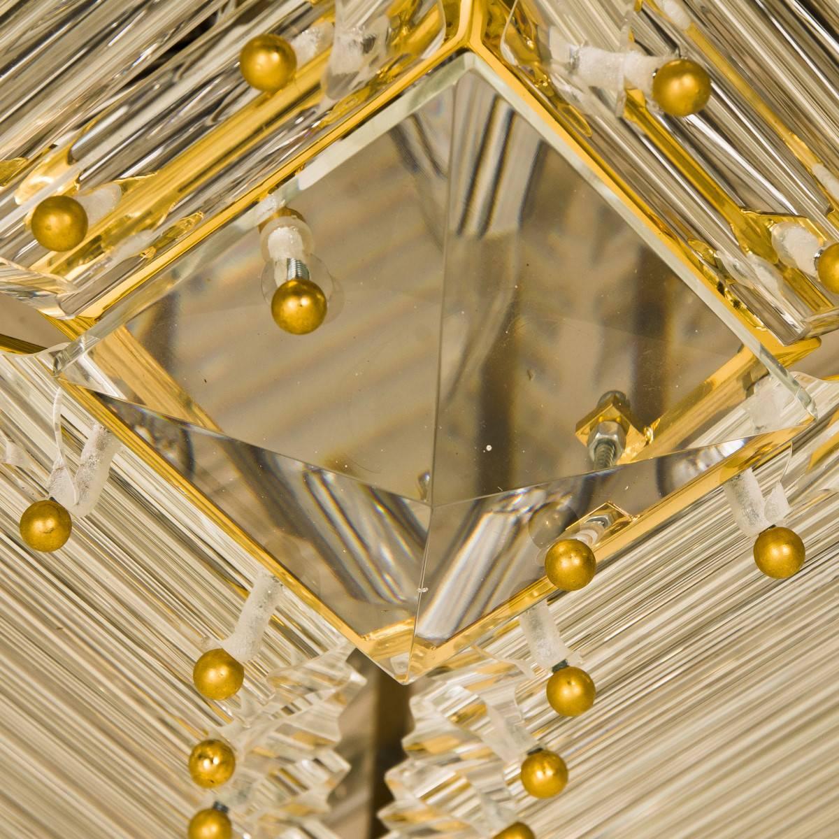 A gold-plated Venini flush mount with faceted clear crystal tubes of Murano glass. Modellated in the form of a piramide. The flush mounts are designed and produced by Venini in Italy from the1970s. The Murano tubes are suspended on a gold plated