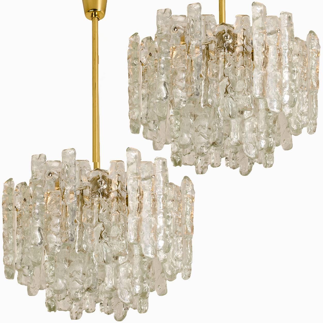 Pair of beautiful and elegant modern brass chandeliers, manufactured by Kalmar Austria in the 1970s. Lovely design, executed to a very high standard. Each chandelier has two layers of extremely stylish textured solid ice glass sheets (18 pieces)