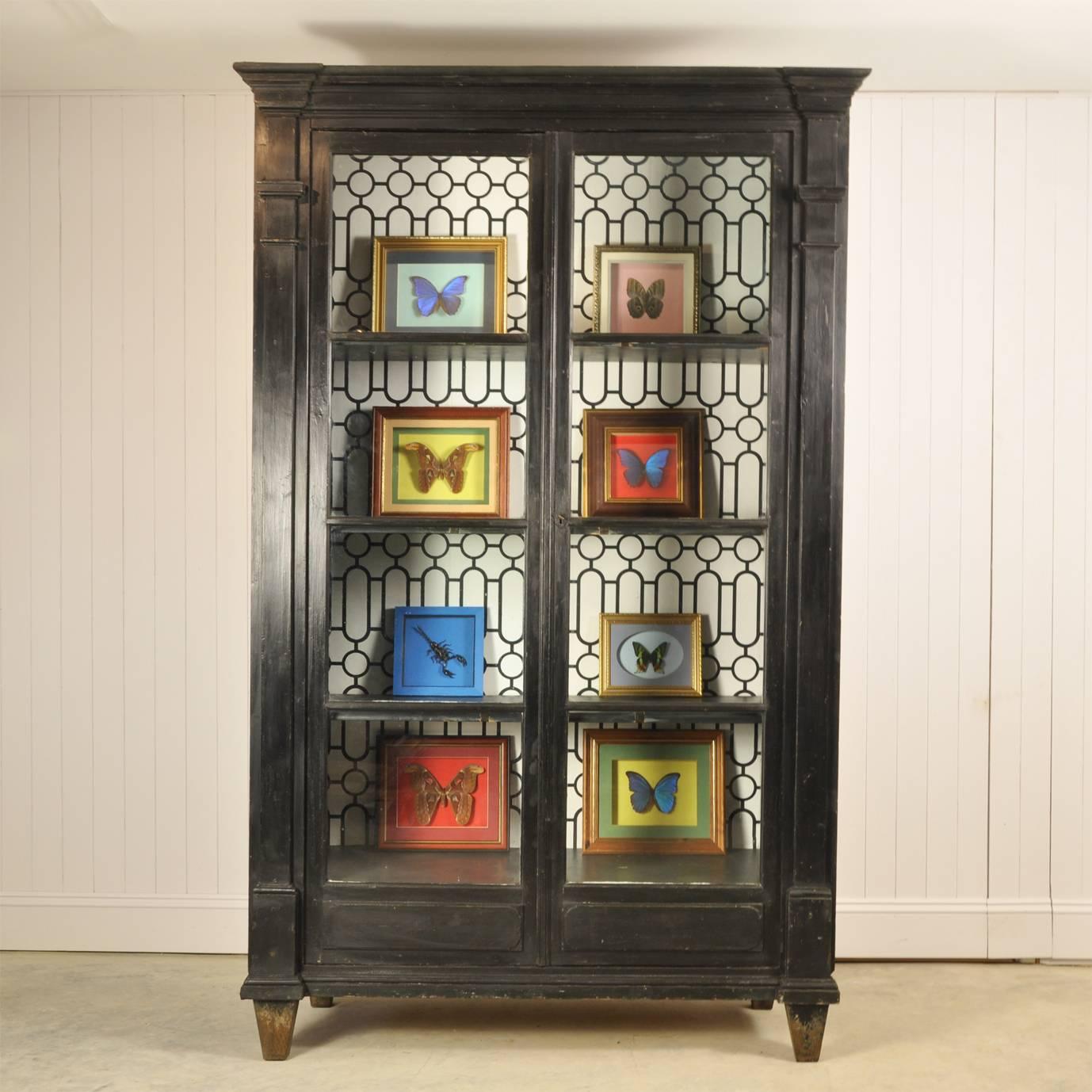 We love how imposing this antique French bookcase is and the beautiful original wavy glass. 

We believe that the black paint is original as it has plenty of patina to it and a few bumps and scrapes - all part of its character.  Please look