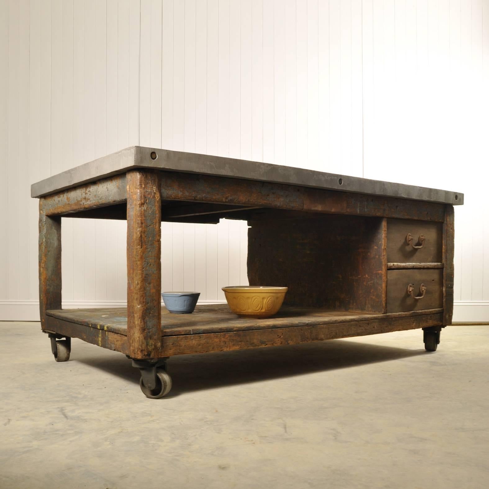This is a new idea for us. Taking a vintage English Industrial workbench on castors with plenty of ware and natural patina, that only years of use can create, and adding a contemporary work surface.

The idea is that the top looks like a huge slab