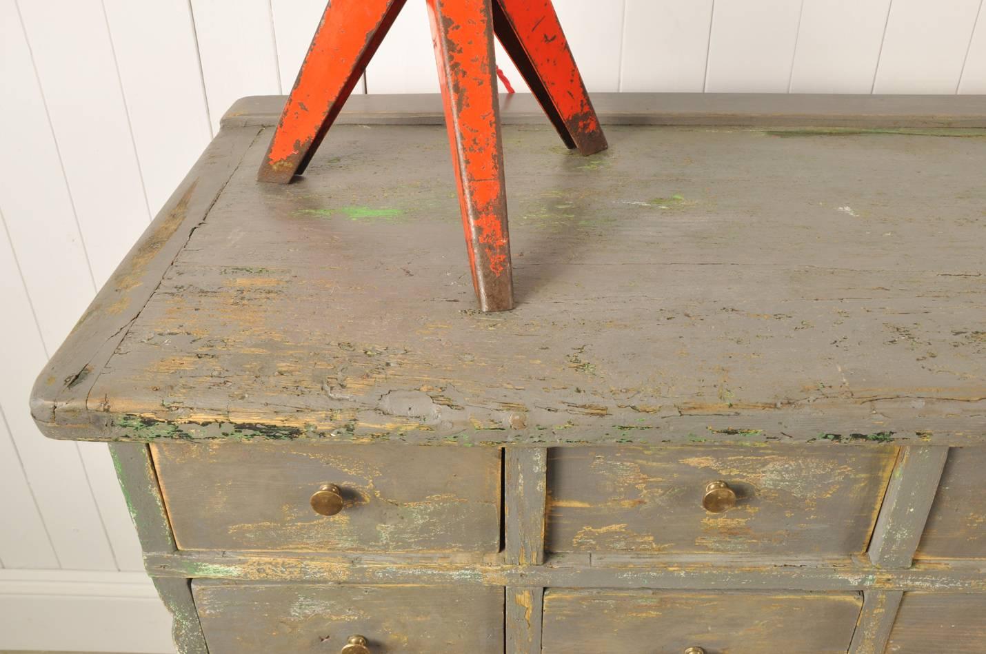 This is a great bank of drawers that we sourced from a textile factory in Belgium. 

It has a lovely finish to the paintwork which has been touched up and then rubbed back in places, revealing different layers and colors.  Lovely little brass