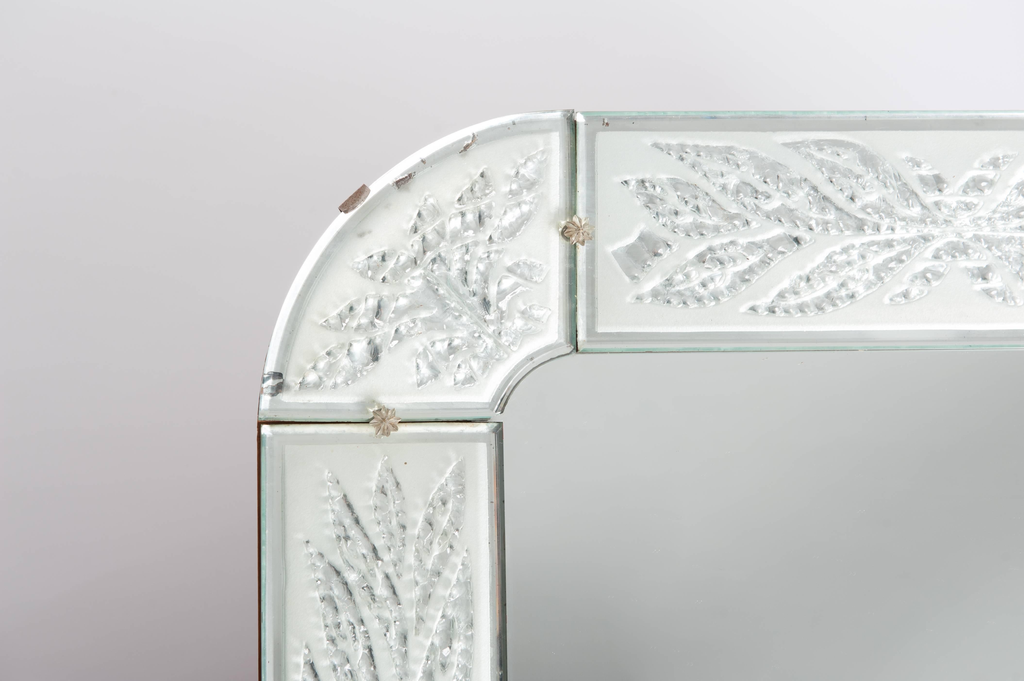 Rare Scandinavian Art Deco mirror designed with sandblasted and clear crystal glass.
The engraving of the frame creates clear elements in the frosted glass that look like frozen stylized leaves.
The sandblasted glass gives the mirror a pastel green