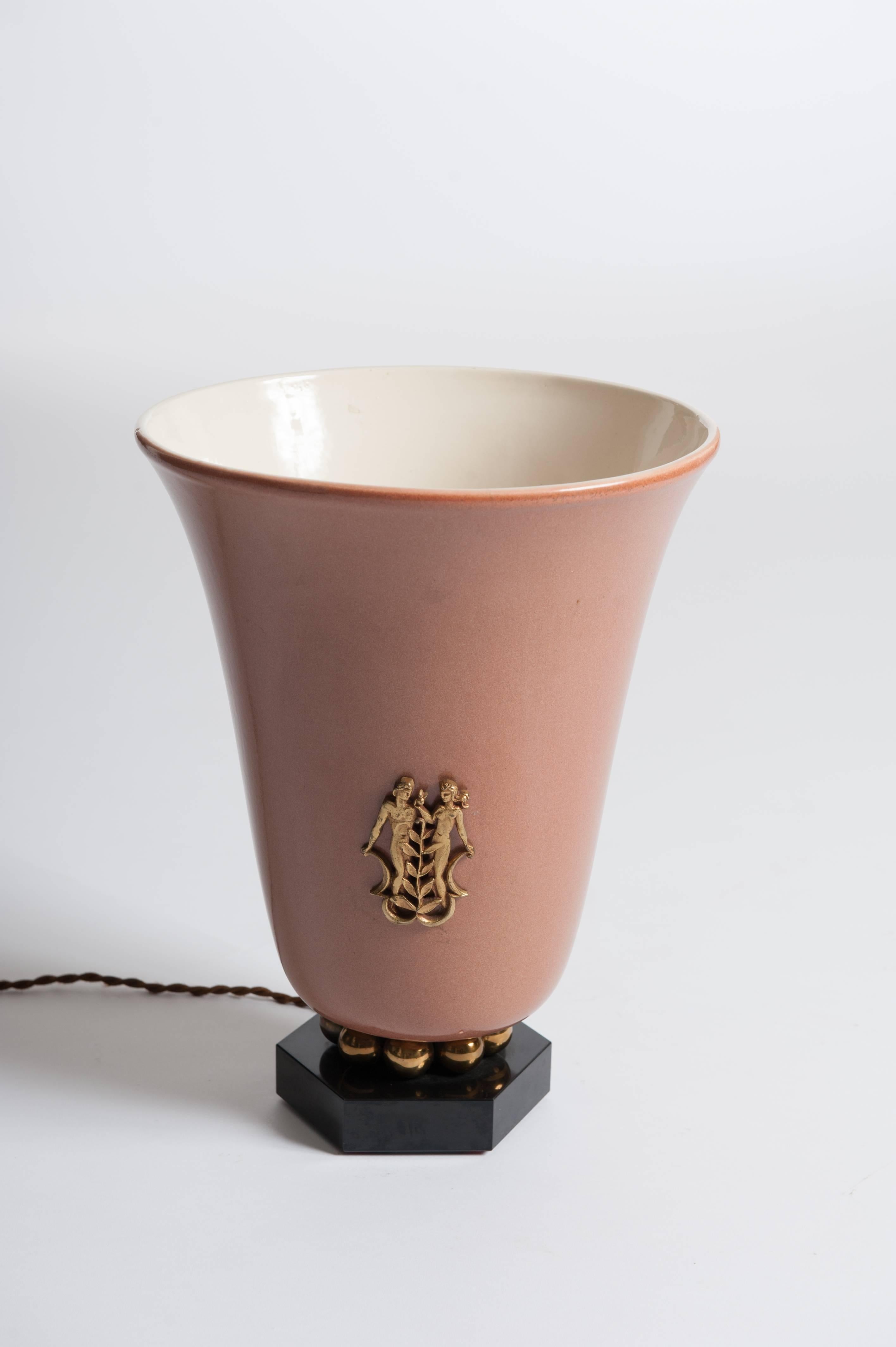 Ceramic shade in a conical design with a slightly outward curved edge in a very decorative brown-sandy color.
The inner wall is creamy white.
The ceramic body has a fine stylized bronze depiction of Adam and Eve in the front.
Eve is holding an apple